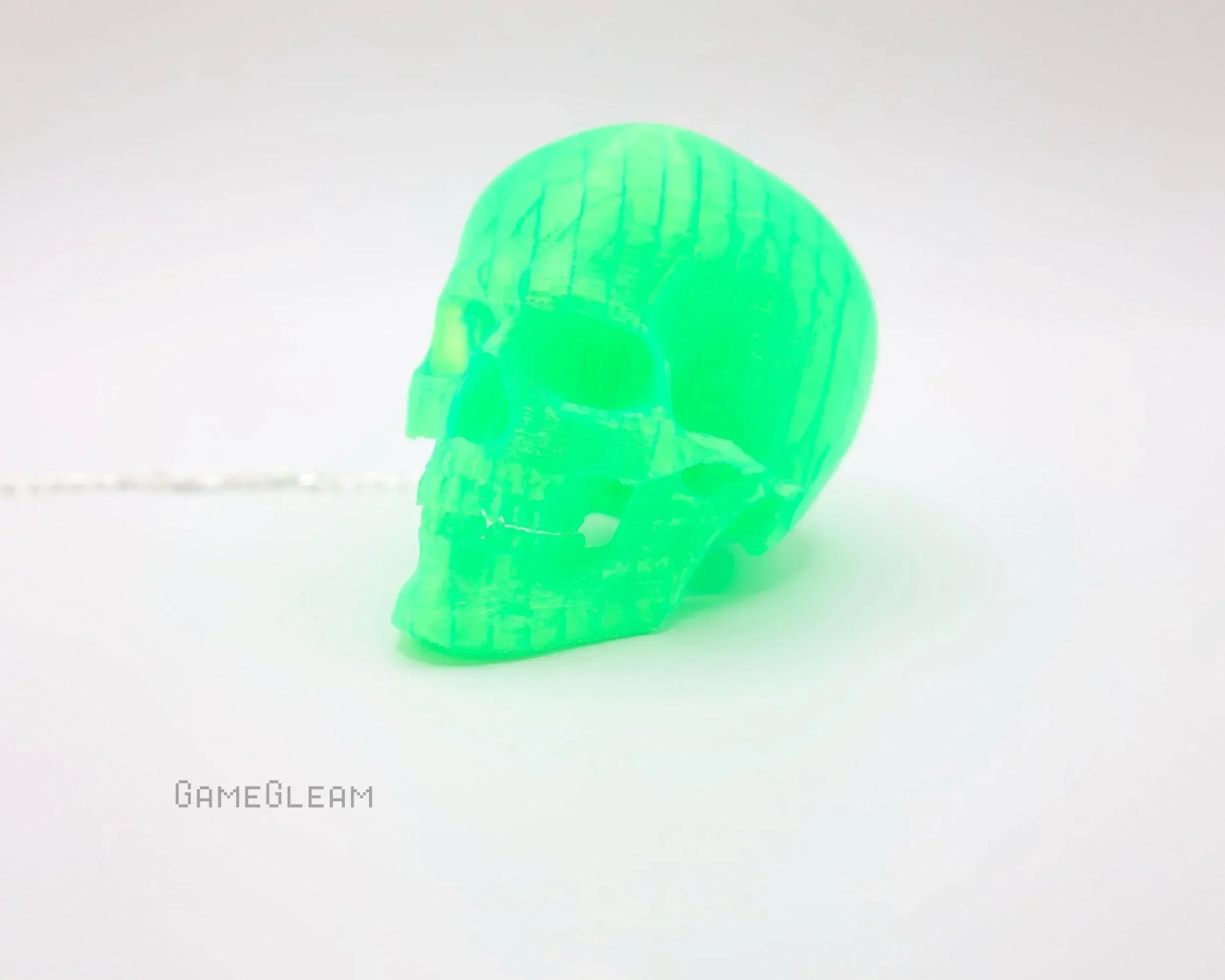 Handmade neon green skull figurine car accessory on white background