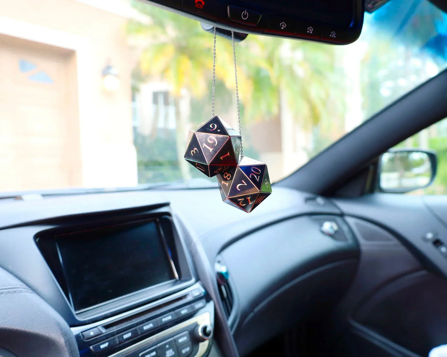 Holographic 20-sided dice car charm hanging from rearview mirror in vehicle interior