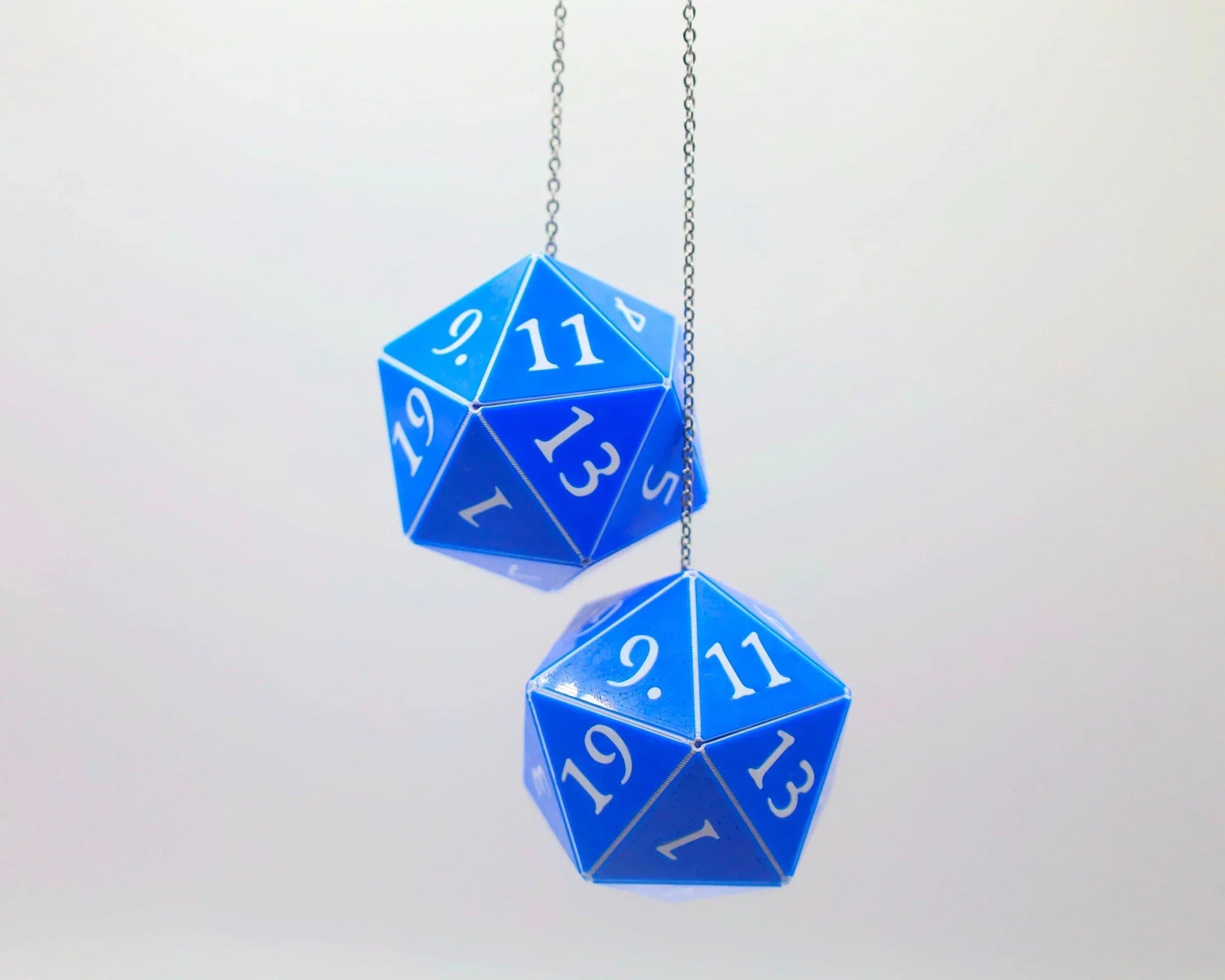 Pair of blue 20-sided dice car charms with white numbers hanging from a chain