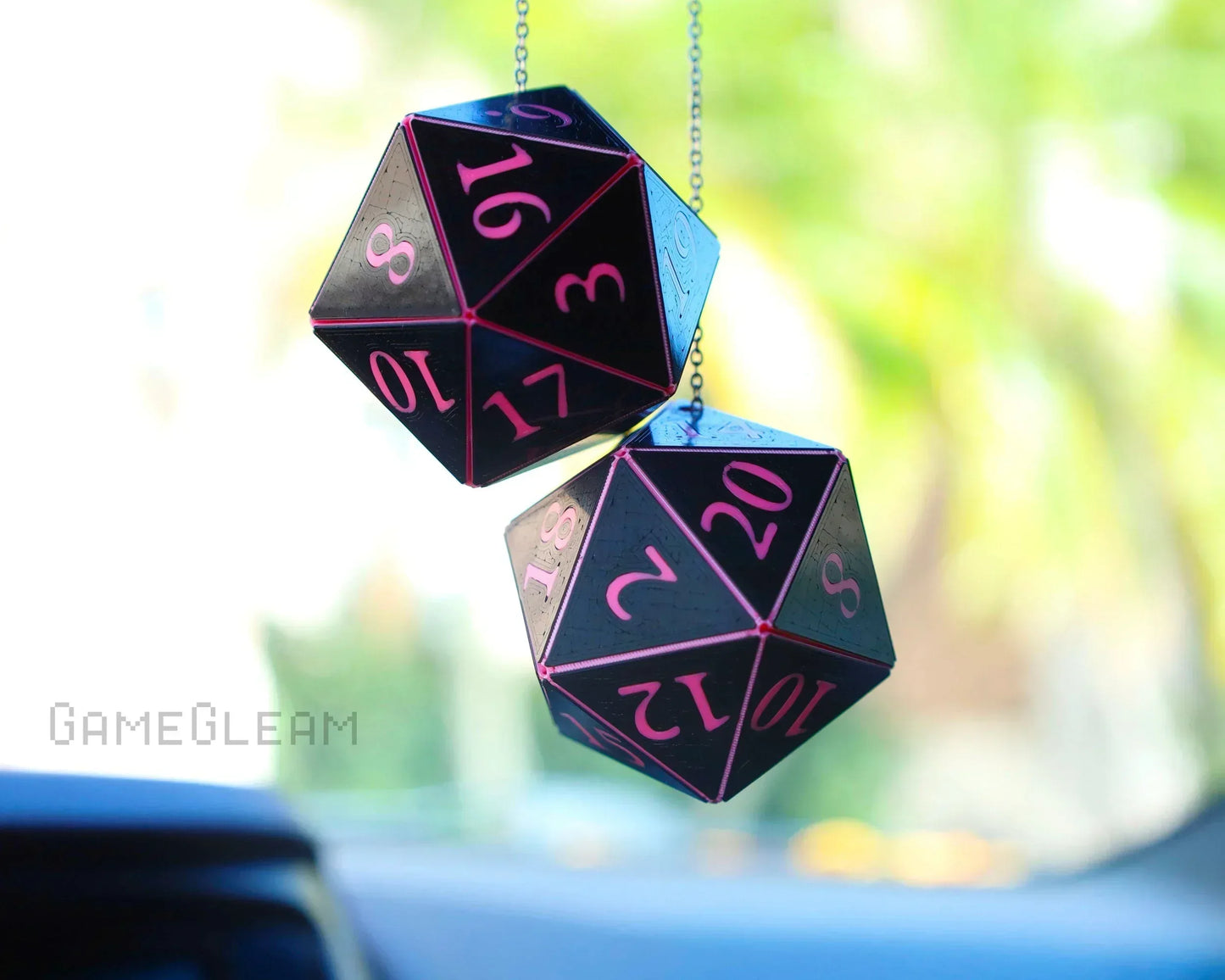 Holographic black 20-sided dice car charm with pink numbers hanging from chain