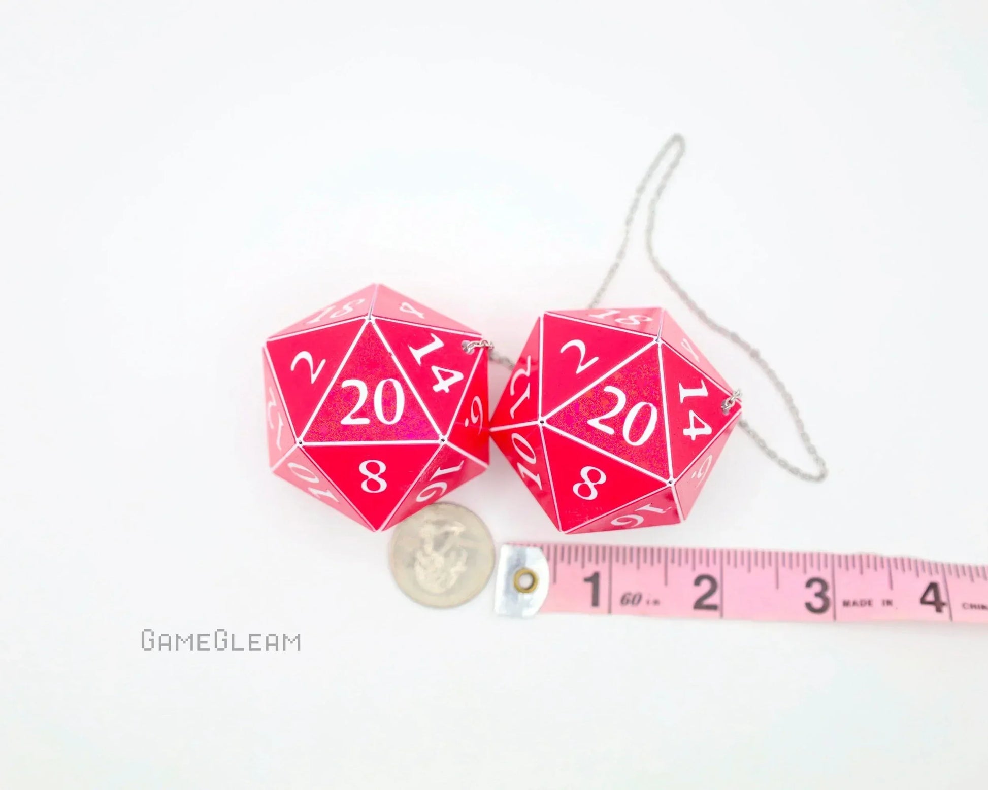 Pink holographic twenty-sided dice car charm pair with measuring tape and coin for scale