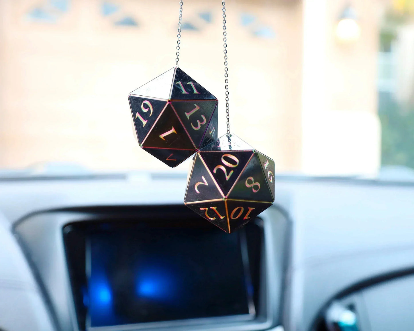 Holographic black twenty-sided dice hanging from car mirror, gamer car accessory