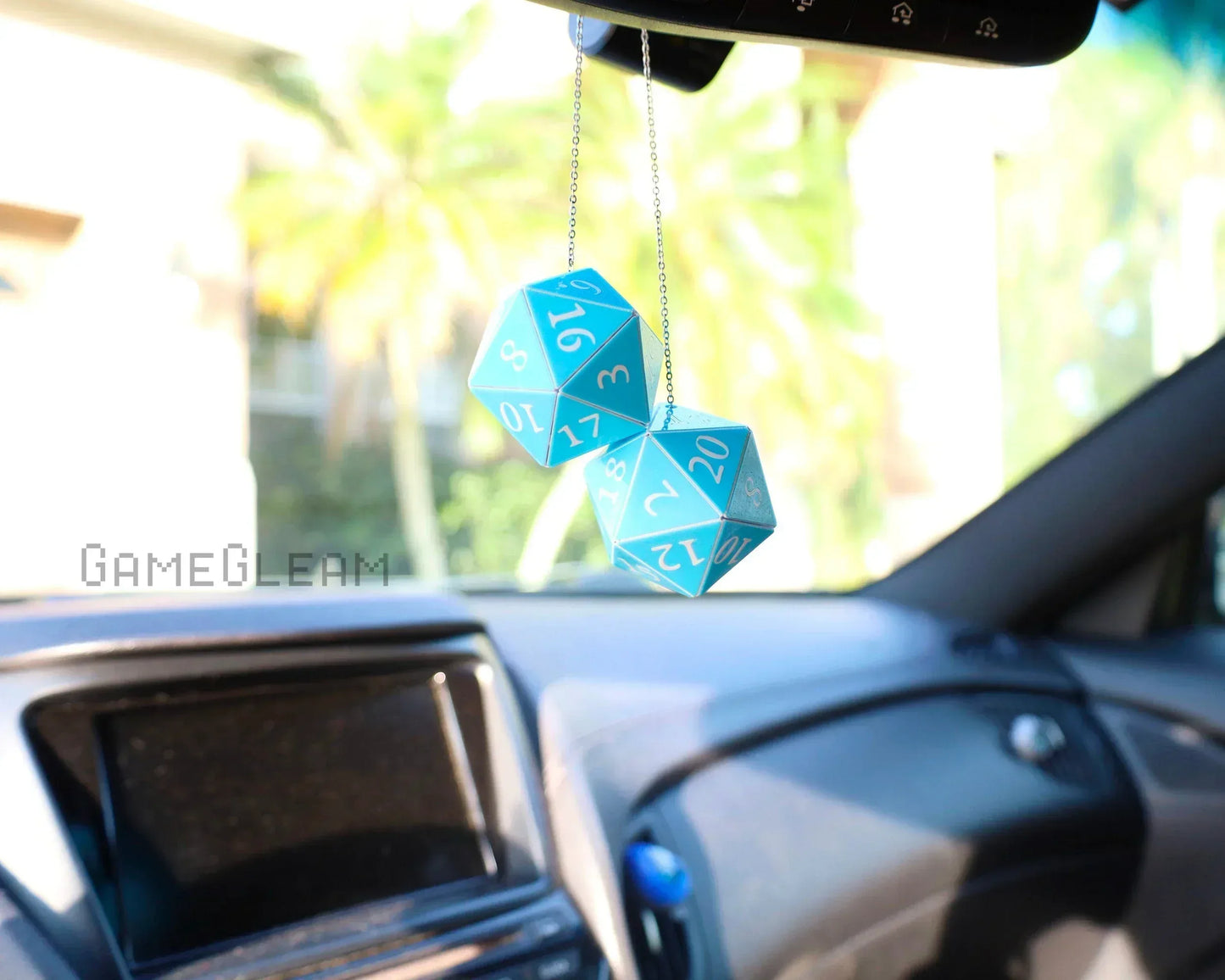 Blue twenty-sided dice hanging as car mirror charm in modern vehicle interior