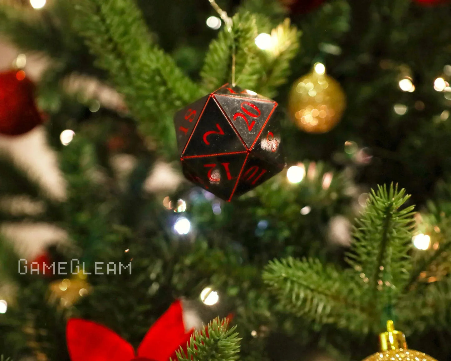 Black and red 20-sided dice ornament hanging on a Christmas tree with festive decorations
