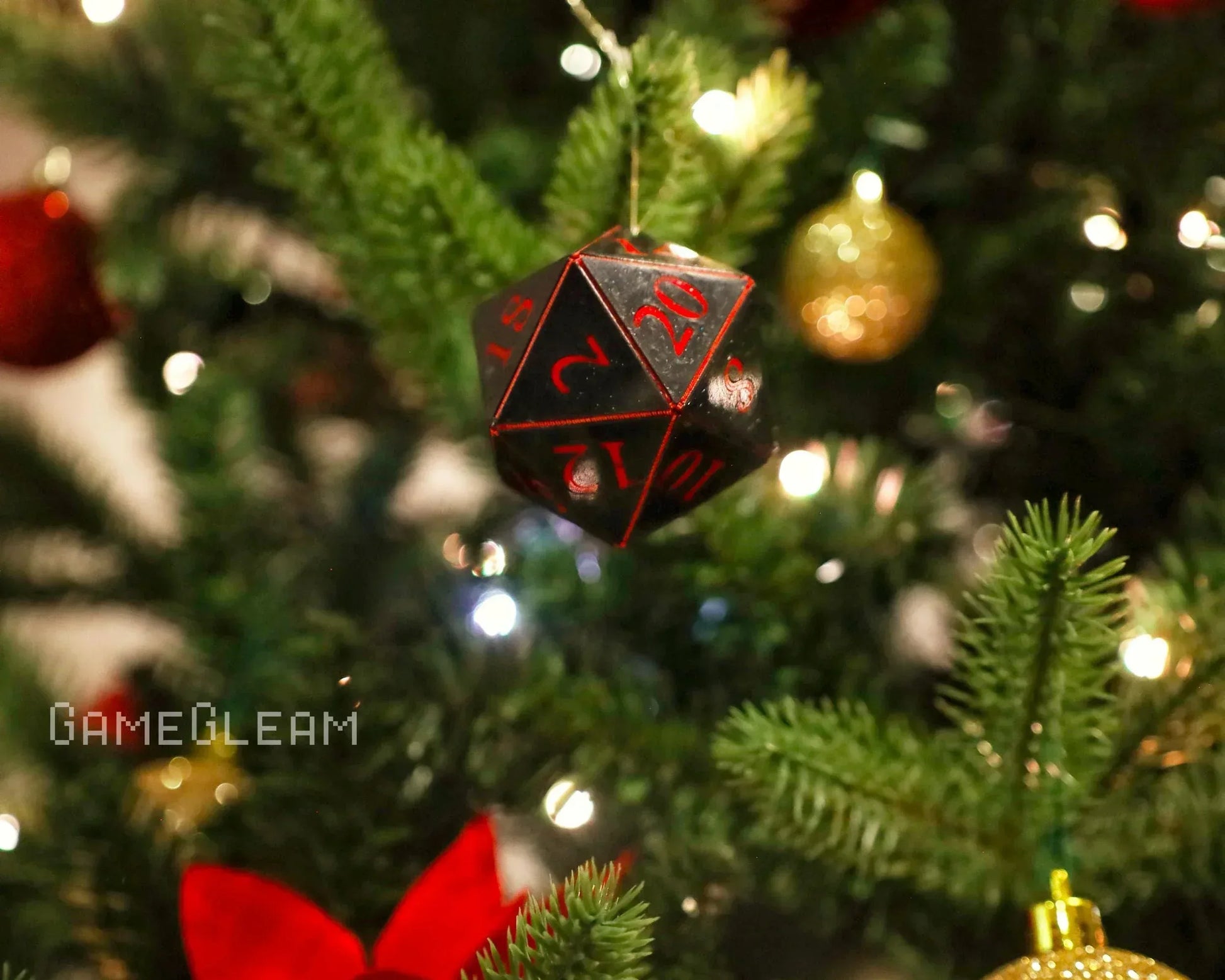 Black and red 20-sided dice ornament hanging on a Christmas tree with festive decorations