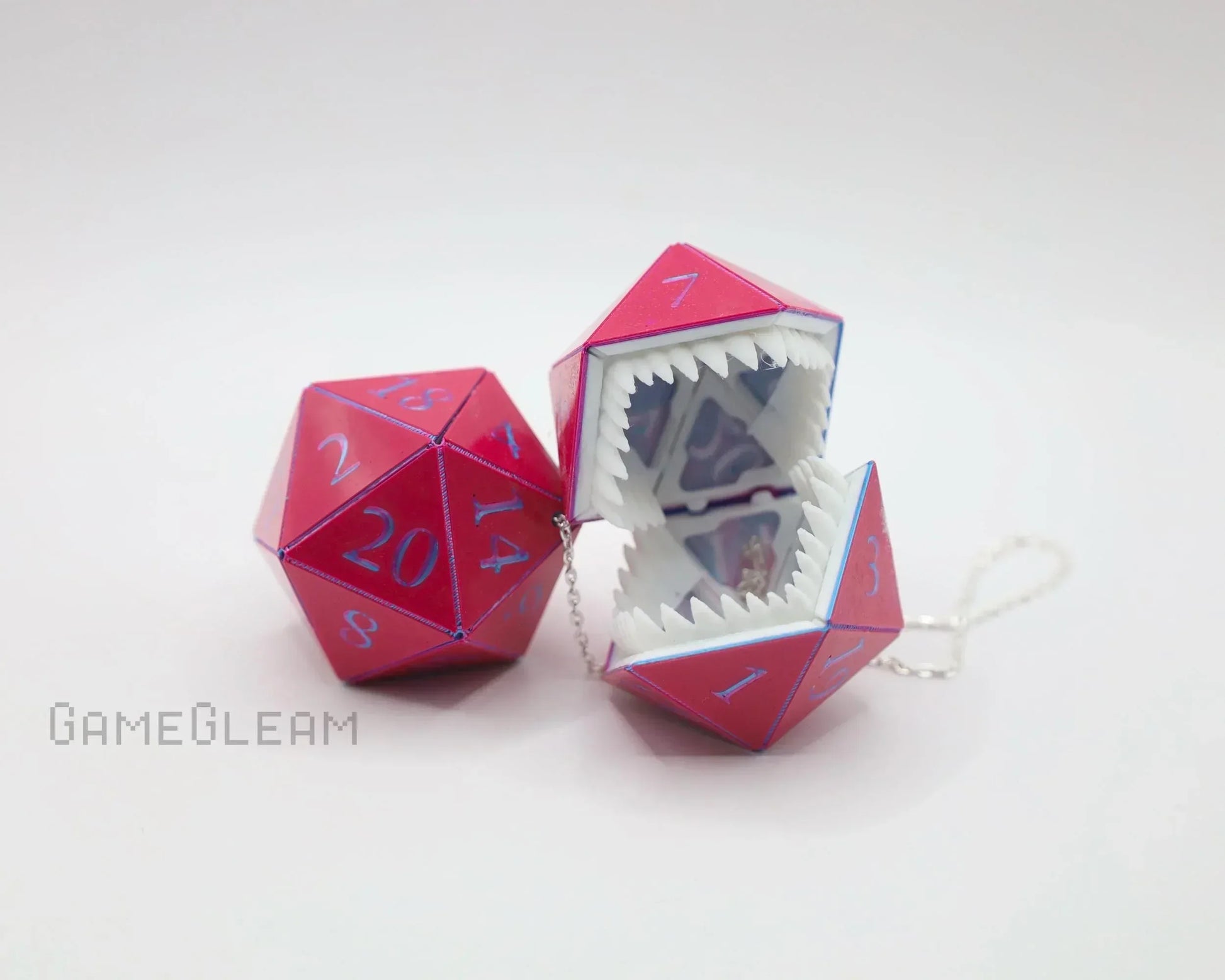 Pink holographic twenty-sided dice with monster mouth design and chain, tabletop gaming accessory