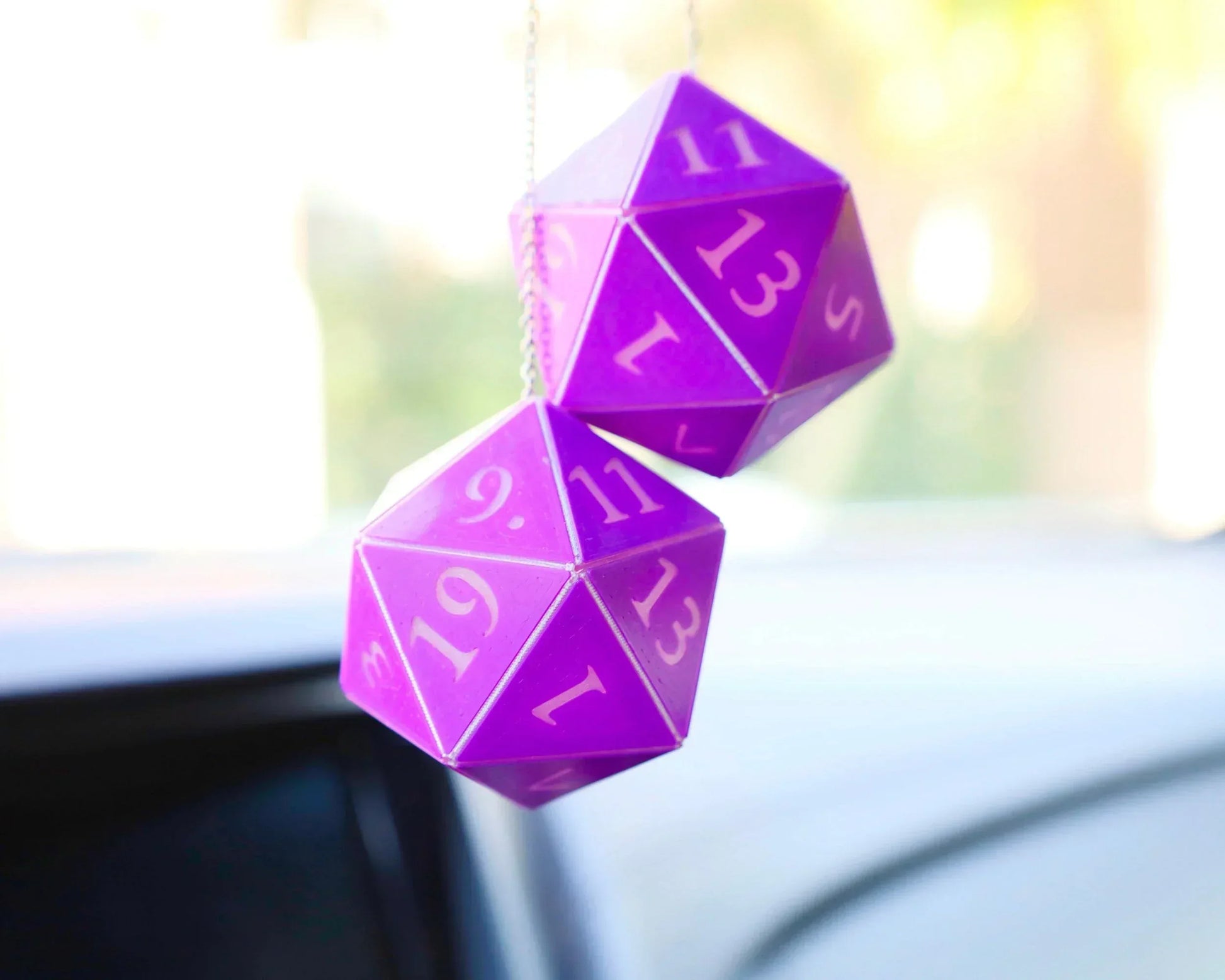 Purple twenty-sided dice car charm hanging from rearview mirror, gamer accessory