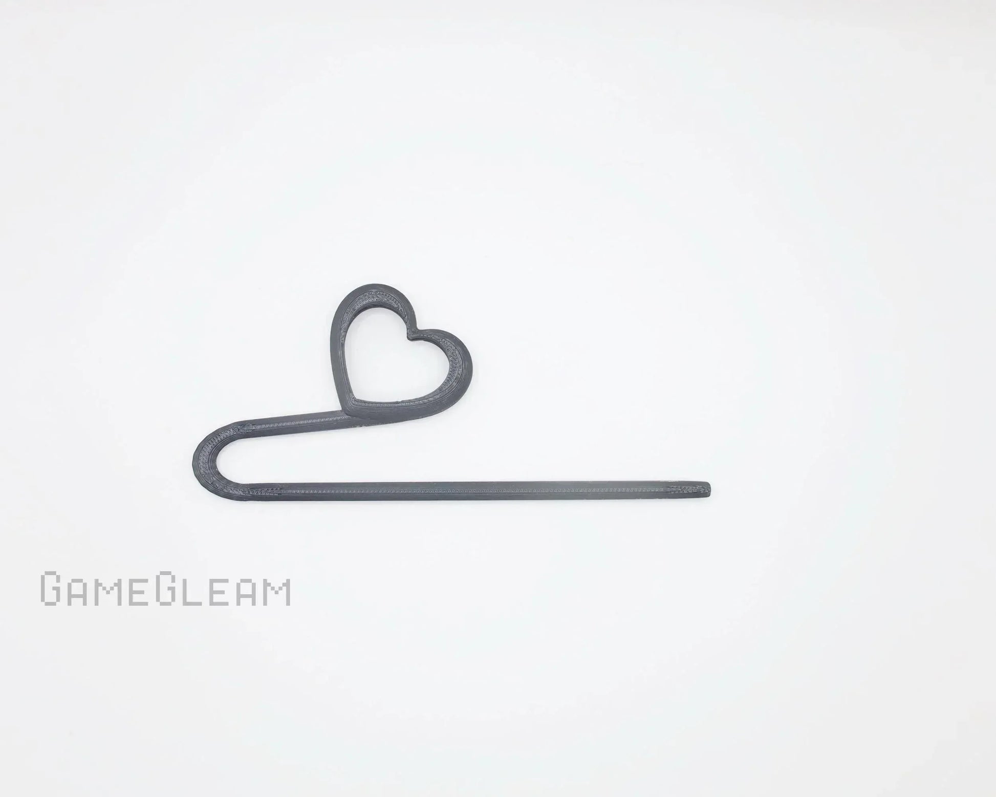 Black heart-shaped hair stick on white background, minimalist handmade accessory