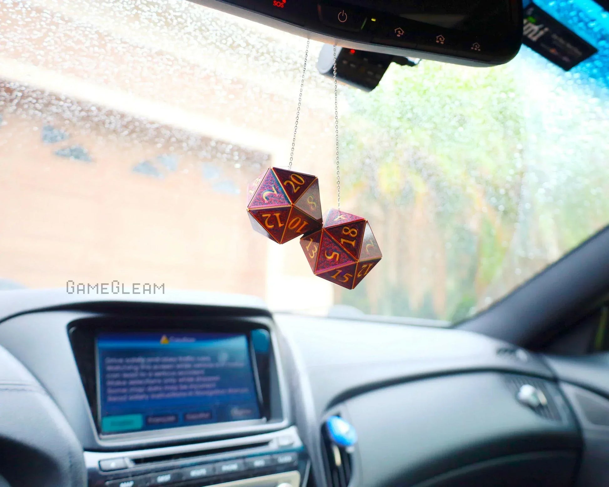 Holographic purple and gold 20-sided dice car charm hanging from rearview mirror