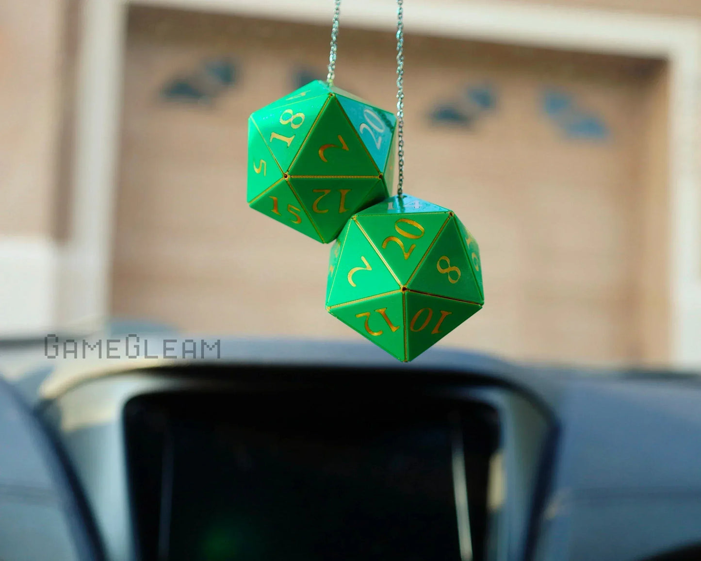 Green twenty-sided dice car charms with gold numbers hanging from rearview mirror