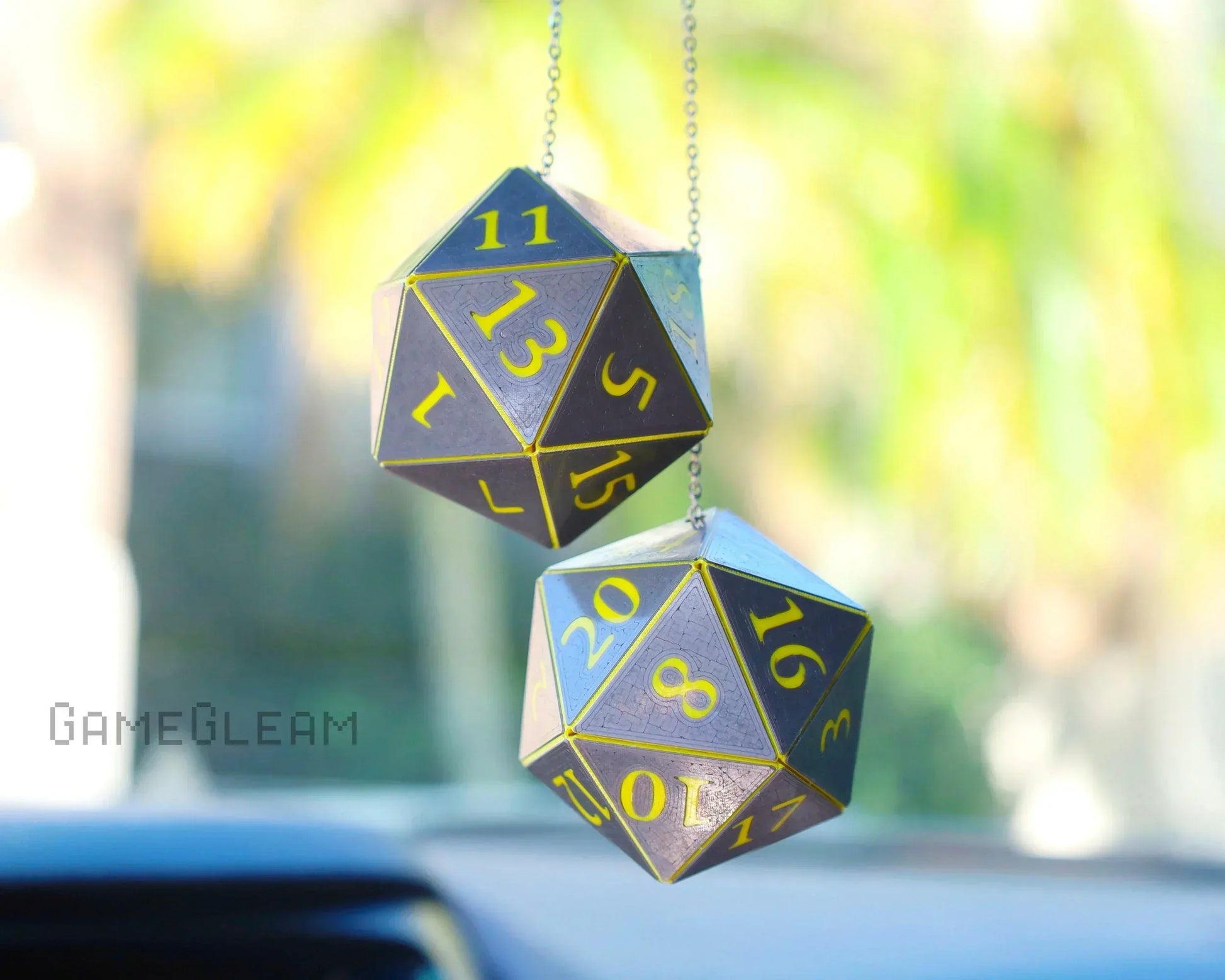 Pair of handmade holographic twenty-sided dice car charms with gold numbers hanging from rearview mirror