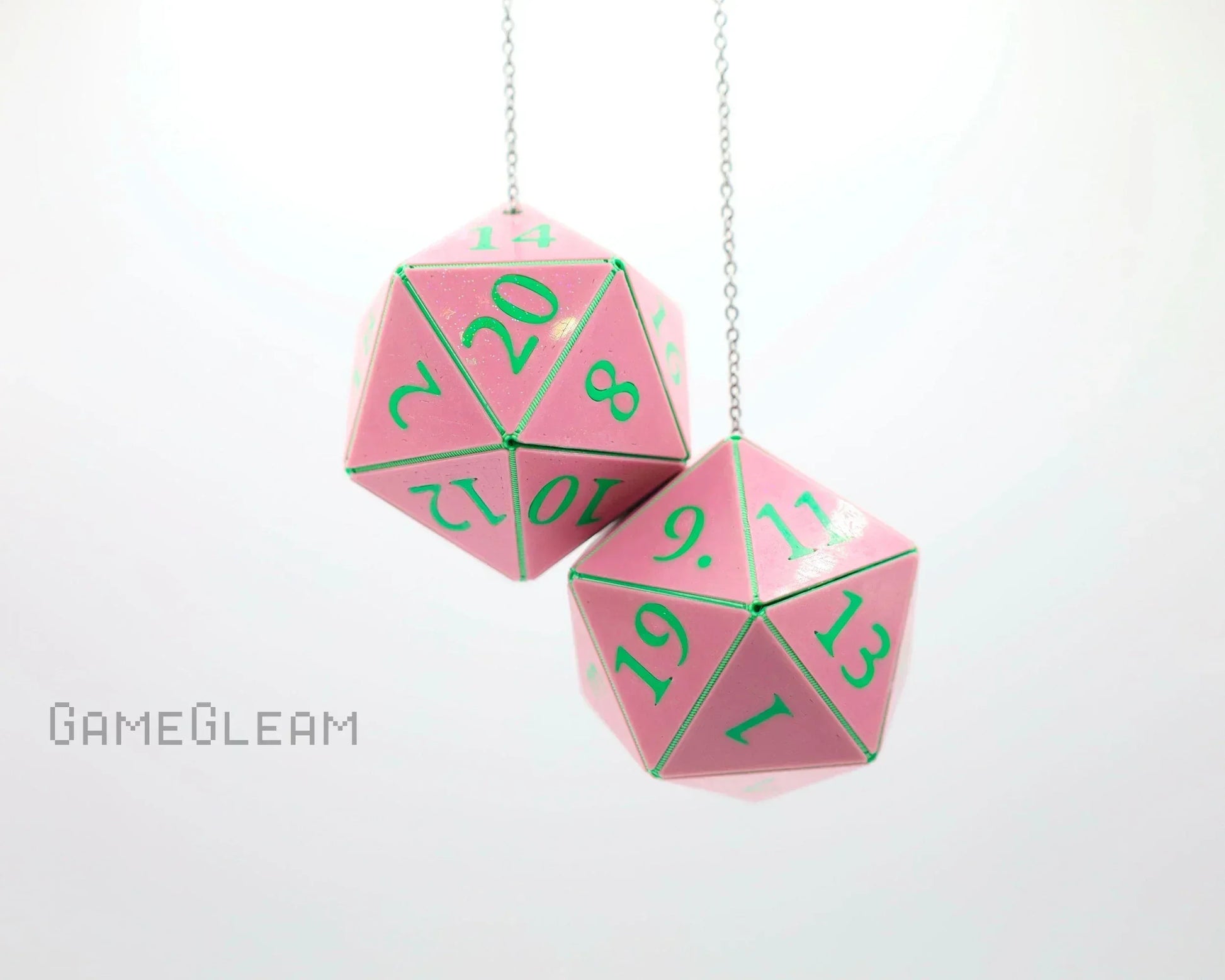 Pink twenty-sided dice car charms with green numbers hanging on silver chains