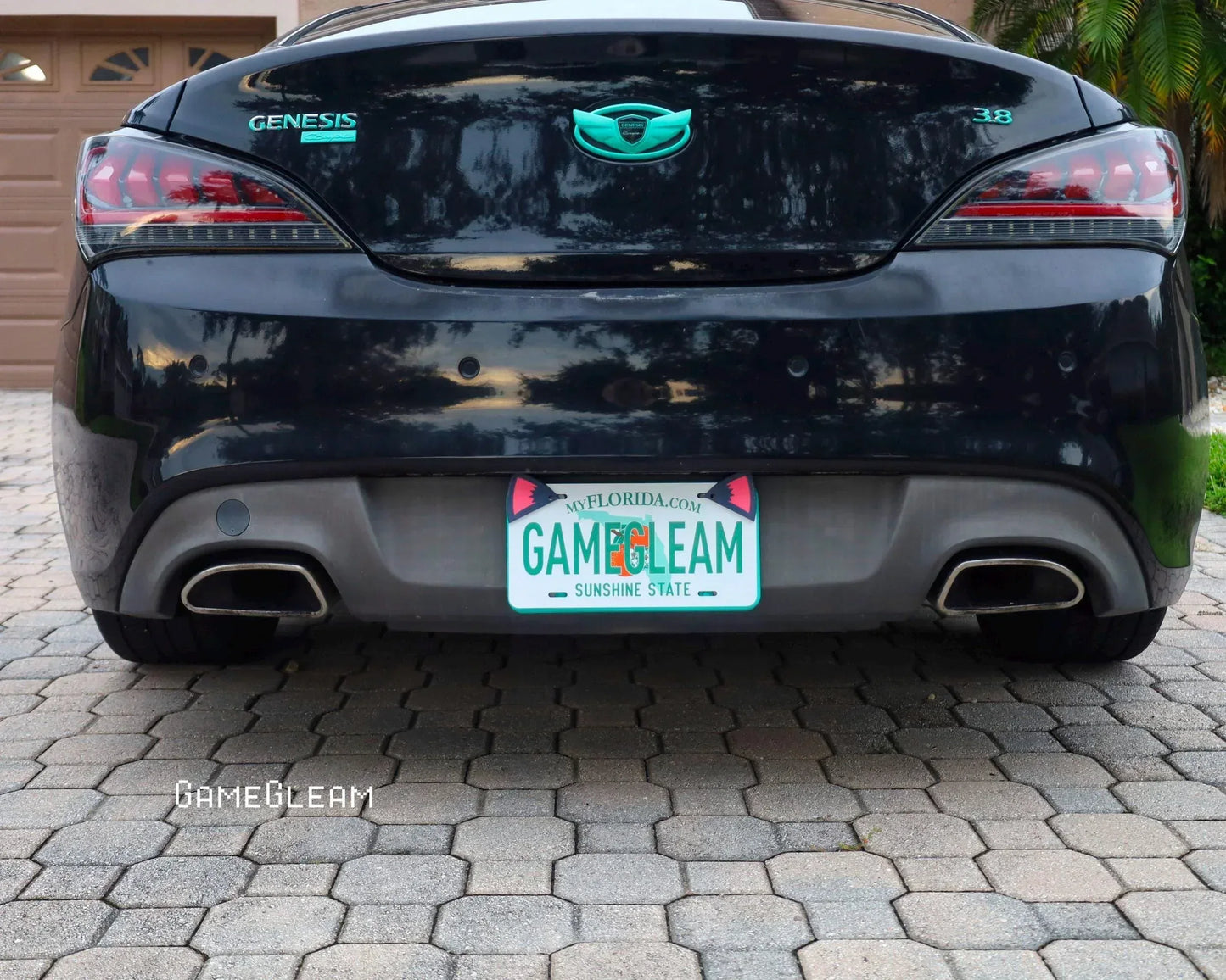 Rear view of black Genesis car with teal emblems and custom GameGleam Florida license plate