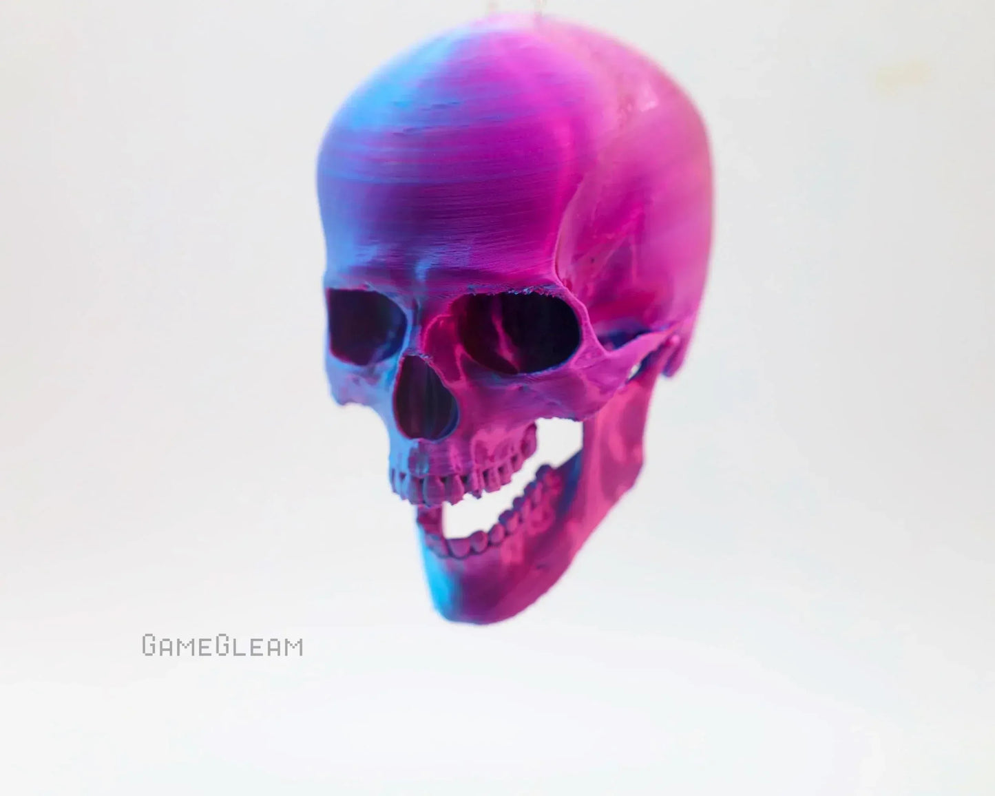 Iridescent pink and blue skull decoration on white background, unique handmade car charm