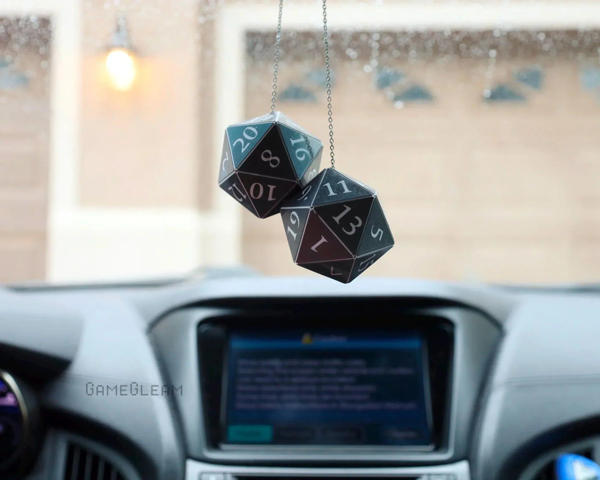 Hanging black twenty-sided dice car charm in a car interior, geek gift decor