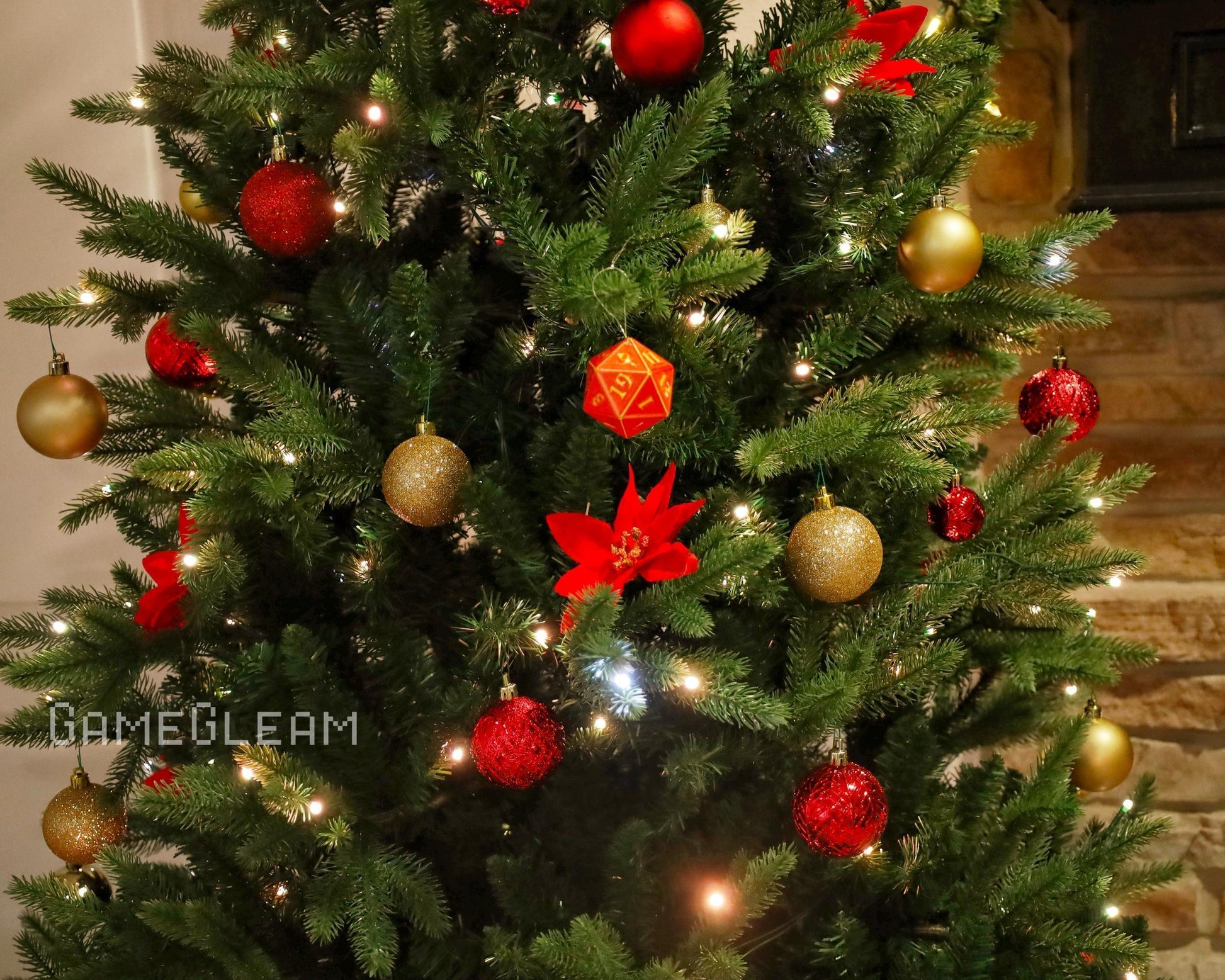 Christmas tree decorated with red and gold baubles, lights, and a large orange polyhedral dice ornament.