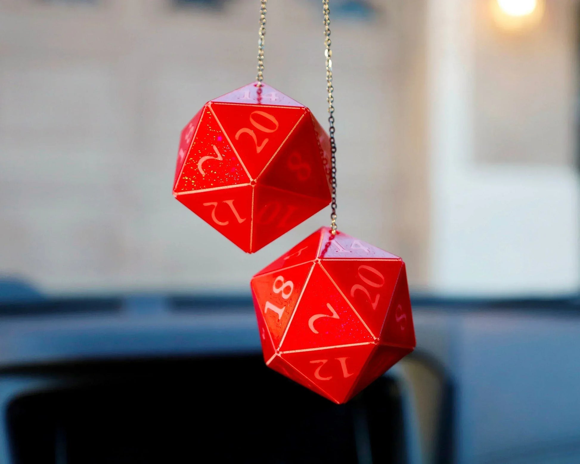 Red twenty-sided dice car charms hanging from rearview mirror, gamer accessory