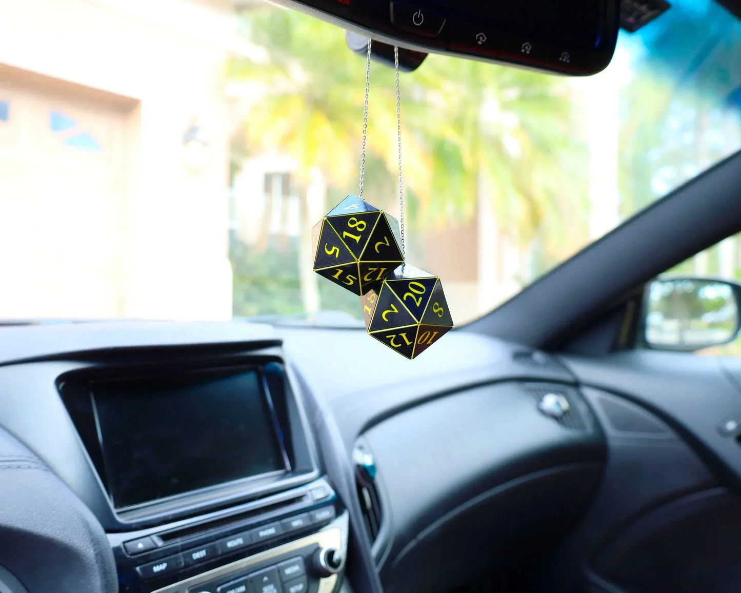 Pair of black and yellow twenty-sided dice hanging as car rearview mirror charm