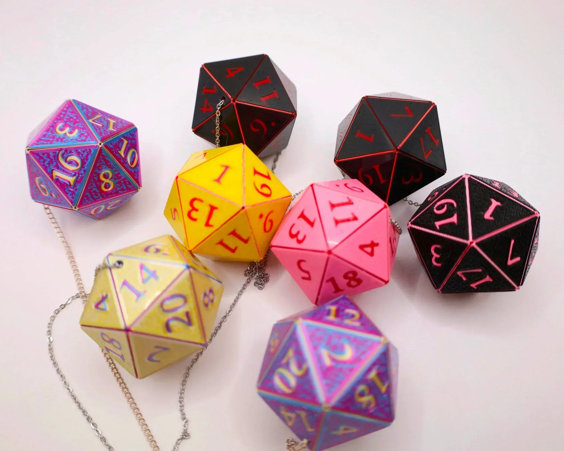 Colorful handmade 20-sided dice charms with chains, displayed on a white background
