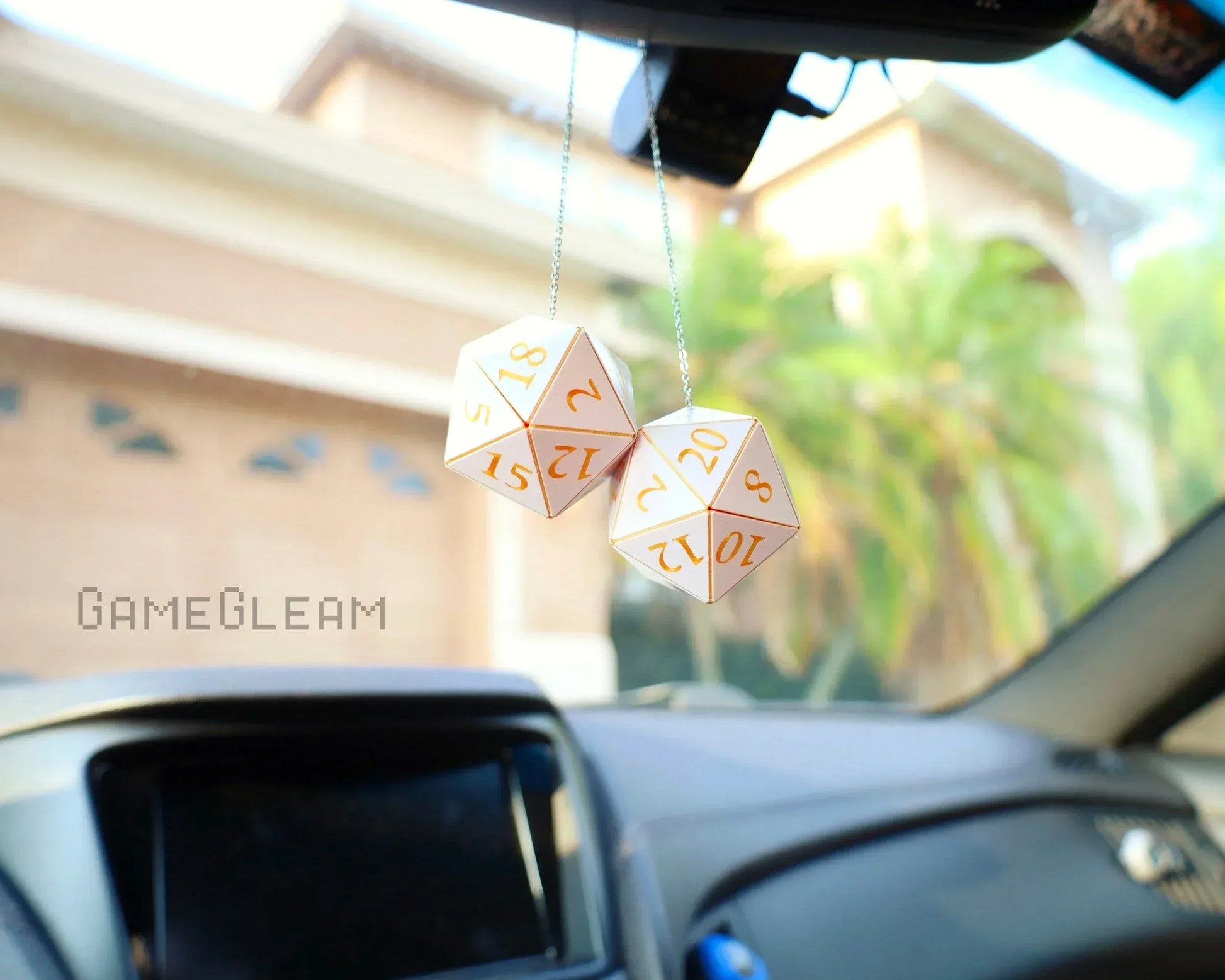 Holographic D20 dice car charm hanging from rearview mirror in a car interior