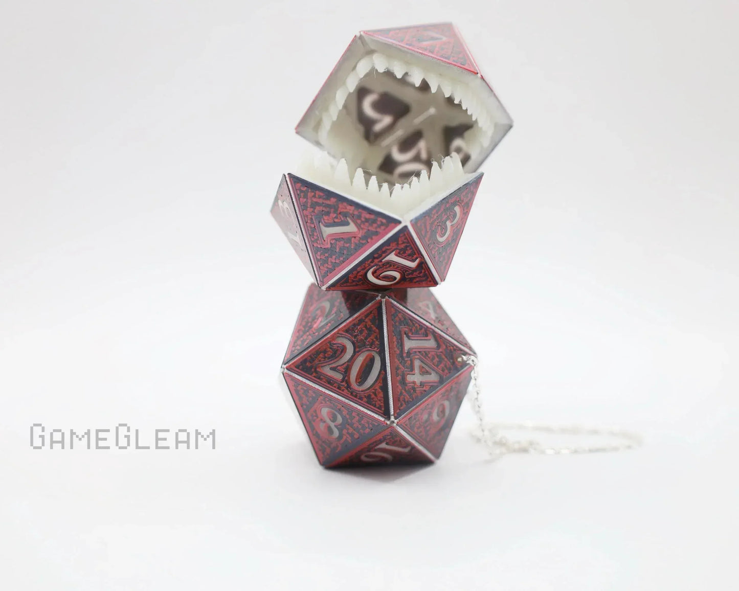 Handmade red polyhedral dice monster charm with open mouth and sharp teeth, chain attached.