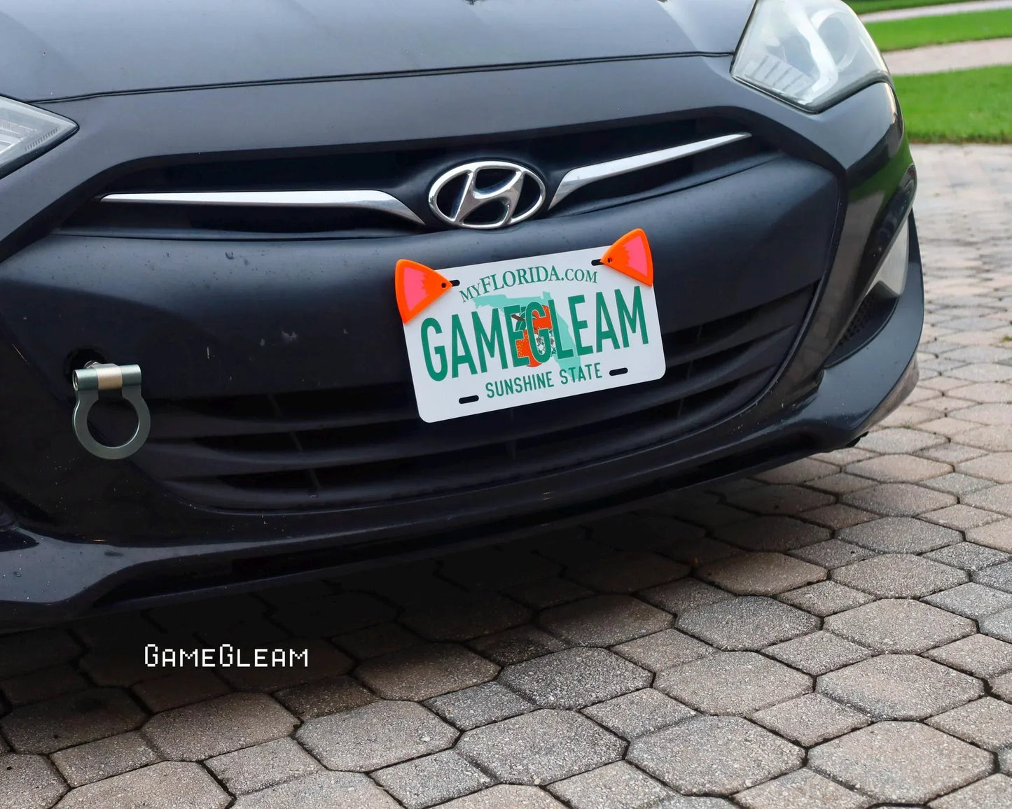 Black Hyundai car with custom Florida gamer-themed license plate and orange cat ear accessories.