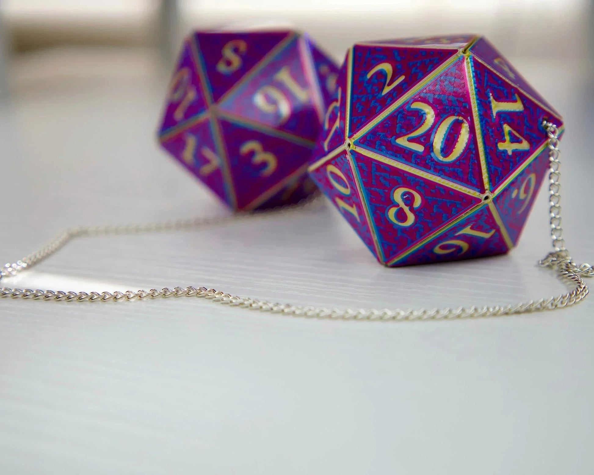 Holographic purple 20-sided dice car charm with gold numbers on a silver chain