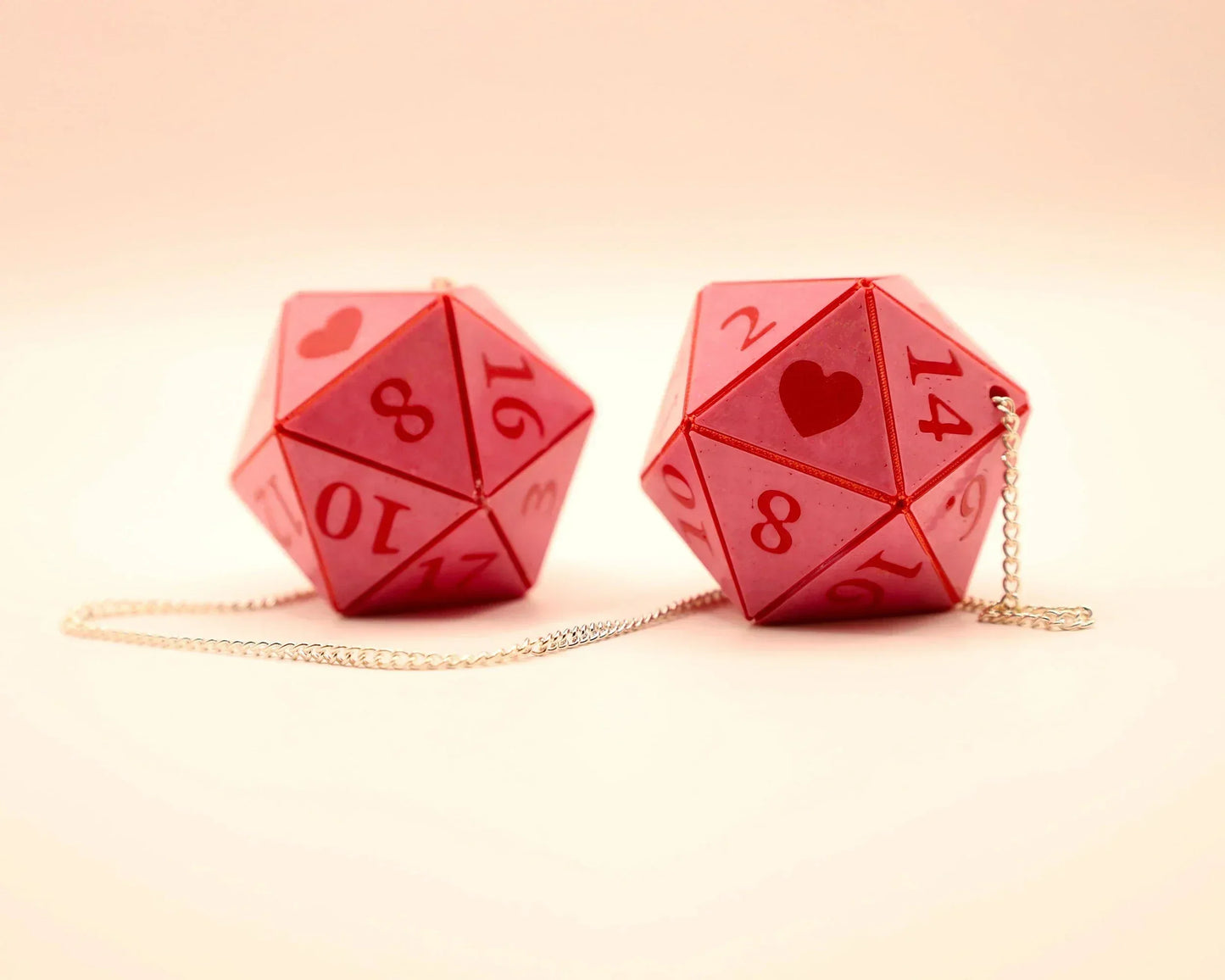 Handmade pink twenty-sided dice car charms with heart and number details on a silver chain