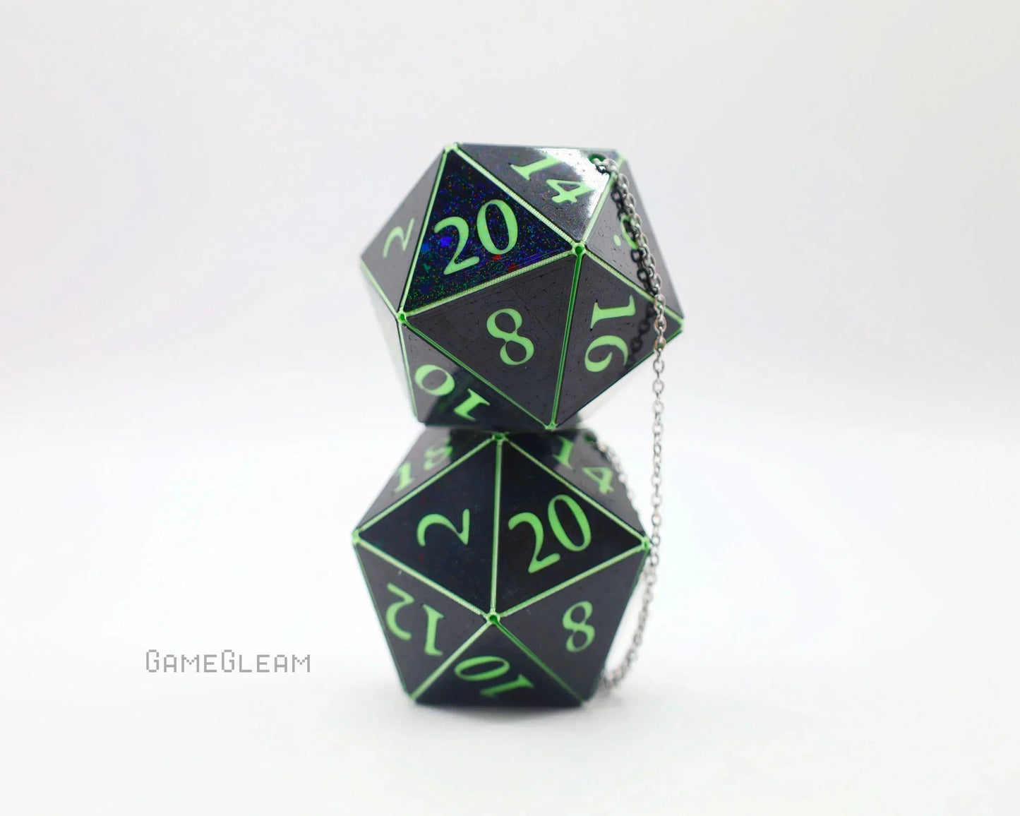 Pair of holographic black twenty-sided dice with neon green numbers and a chain, on white background