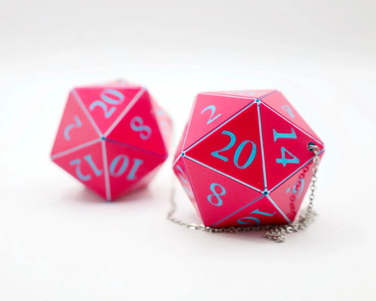Pink 20-sided dice car charms with blue numbers and silver chains, tabletop RPG accessory