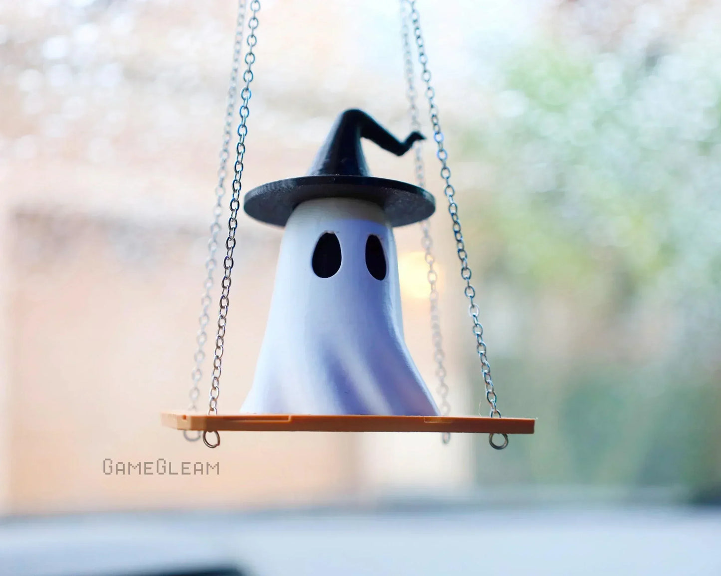 Handmade ghost car charm with witch hat on a swinging platform, hanging by chains