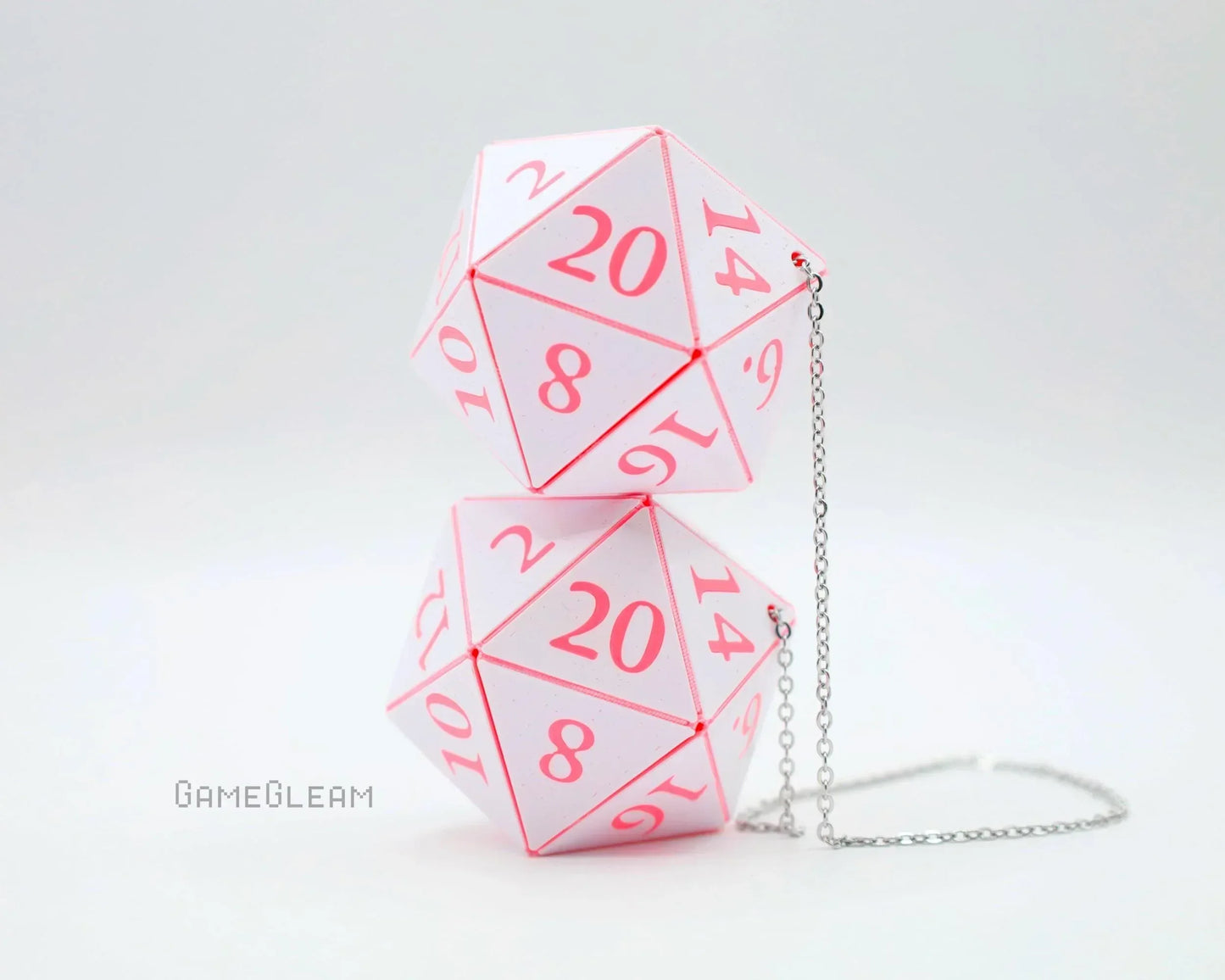 Pink and white twenty-sided dice shaped car mirror charm with silver chain on white background