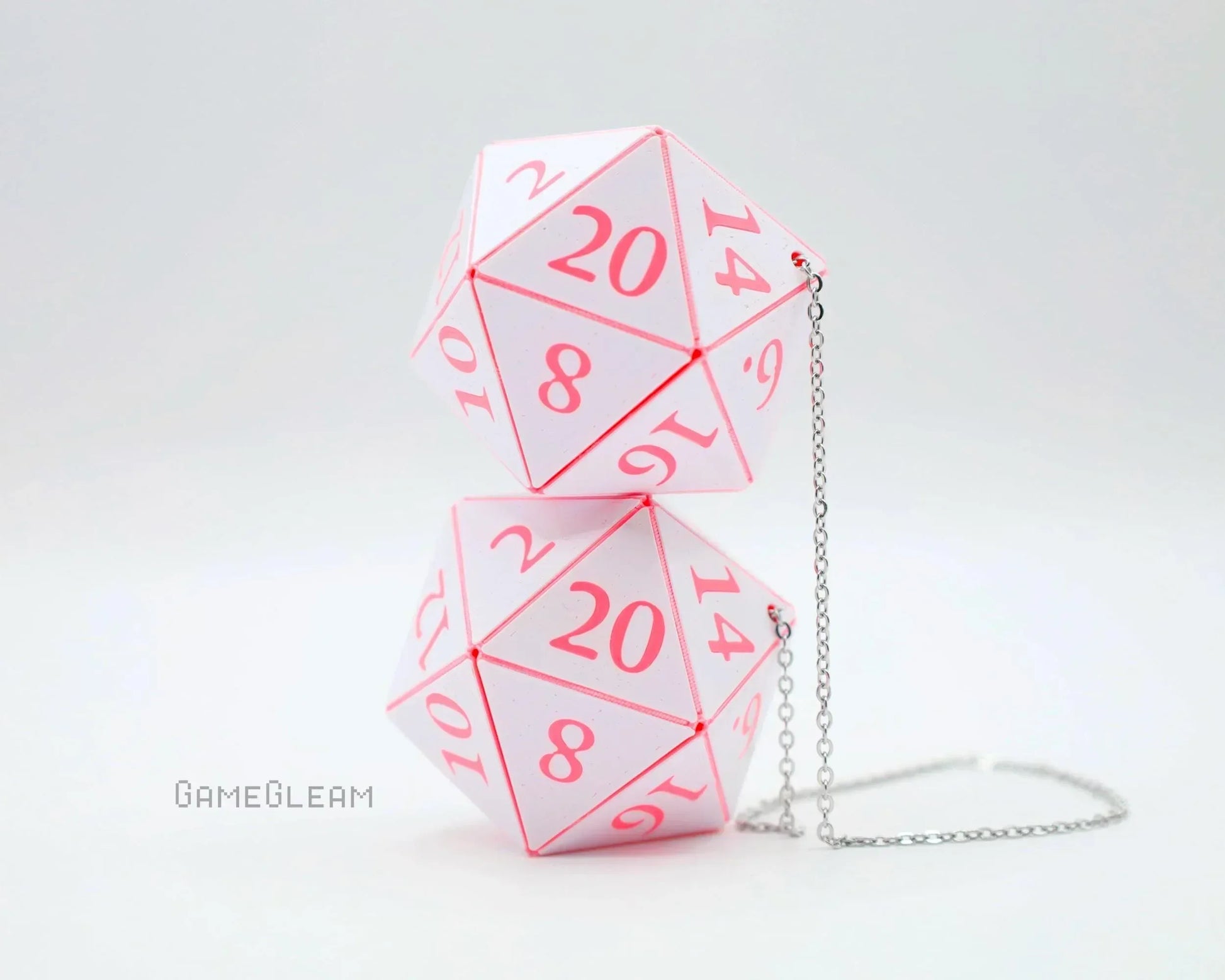 Pink and white twenty-sided dice shaped car mirror charm with silver chain on white background