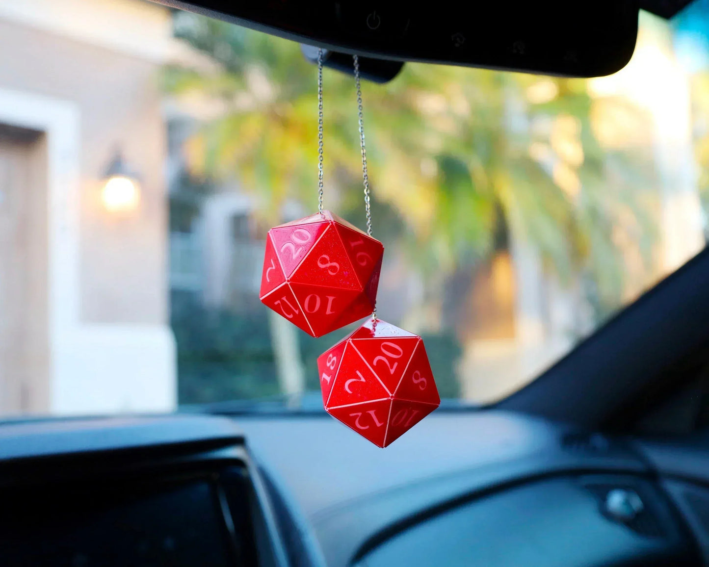 Red twenty-sided dice hanging from a car mirror, gamer car accessory