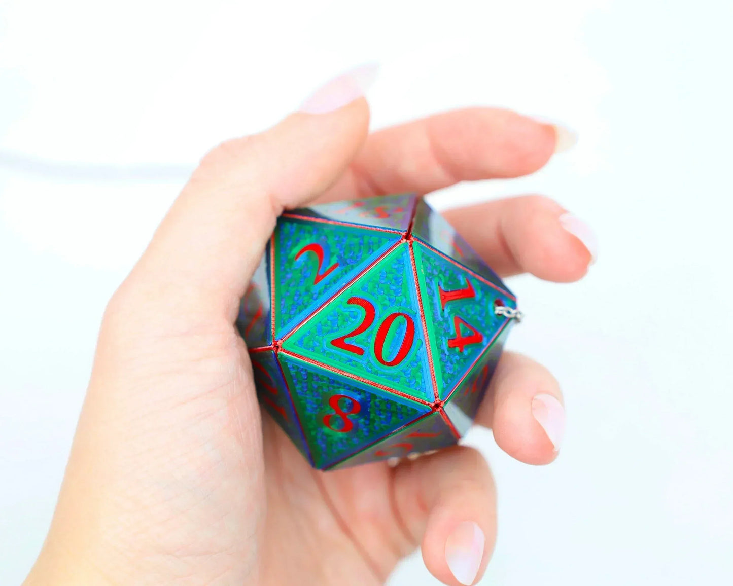 Hand holding a large holographic twenty-sided dice with red numbers, gamer gift accessory