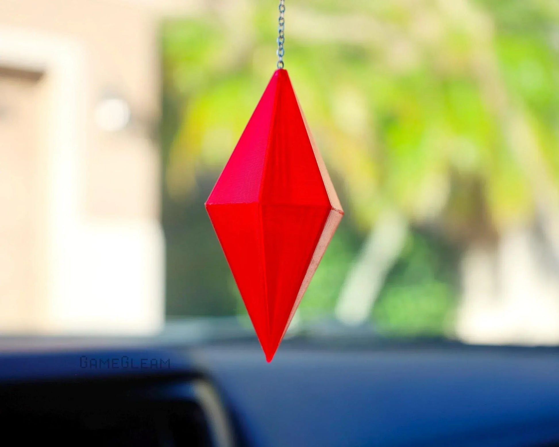 Red geometric prism car charm hanging from rearview mirror, handmade gamer accessory.