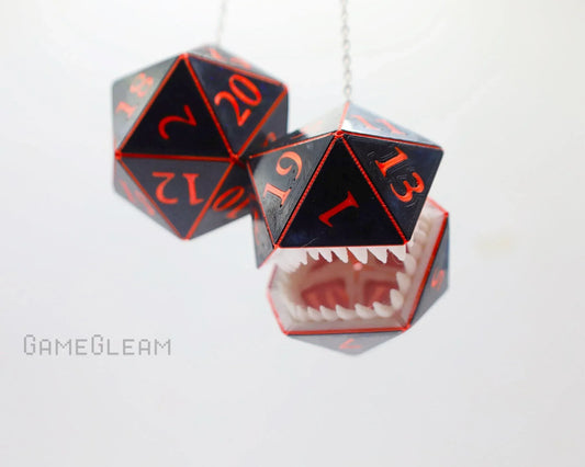 Handmade hanging car charm with two black and red twenty-sided dice, one with monster teeth.