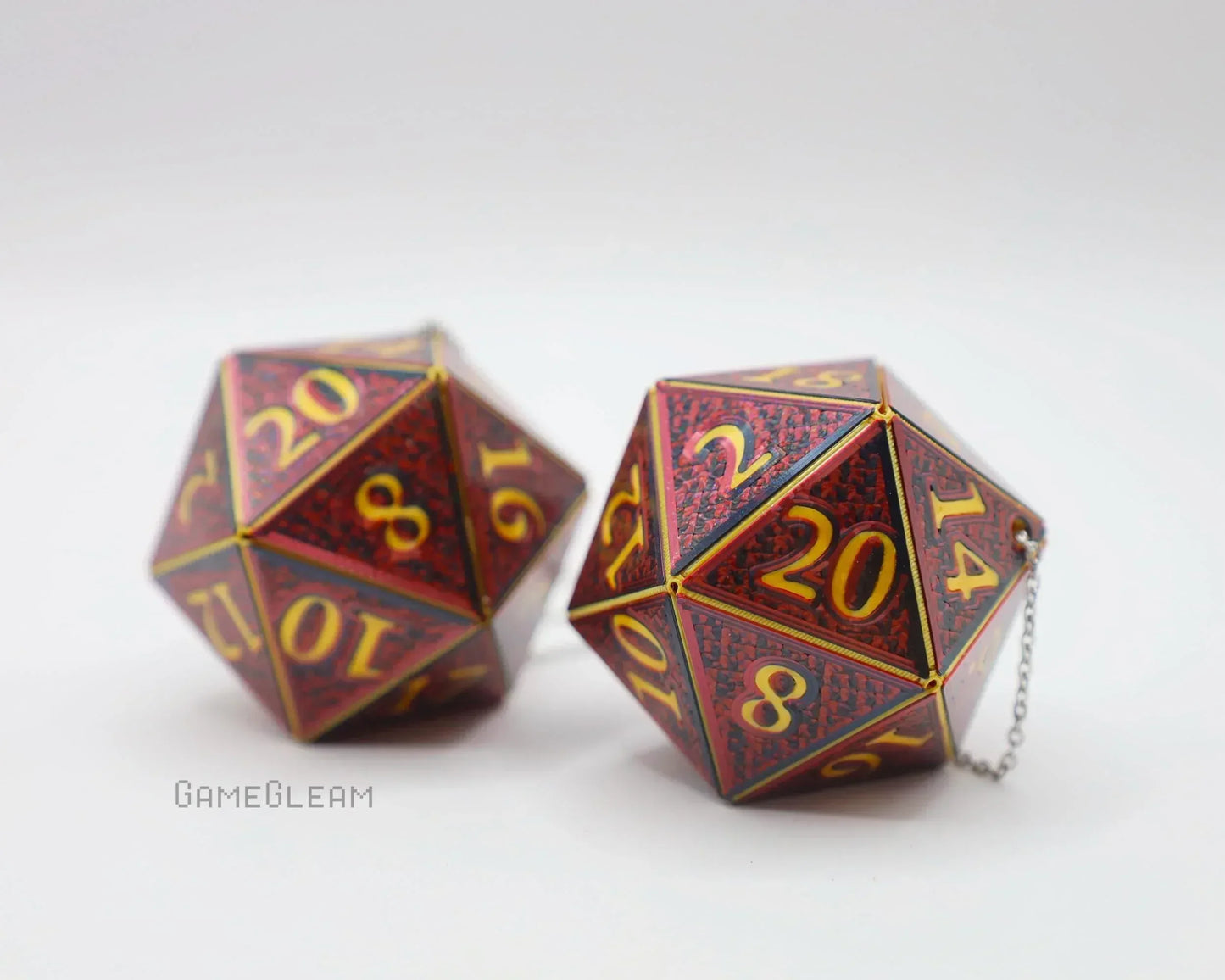 Pair of red and gold twenty-sided dice car charms with chain on white background