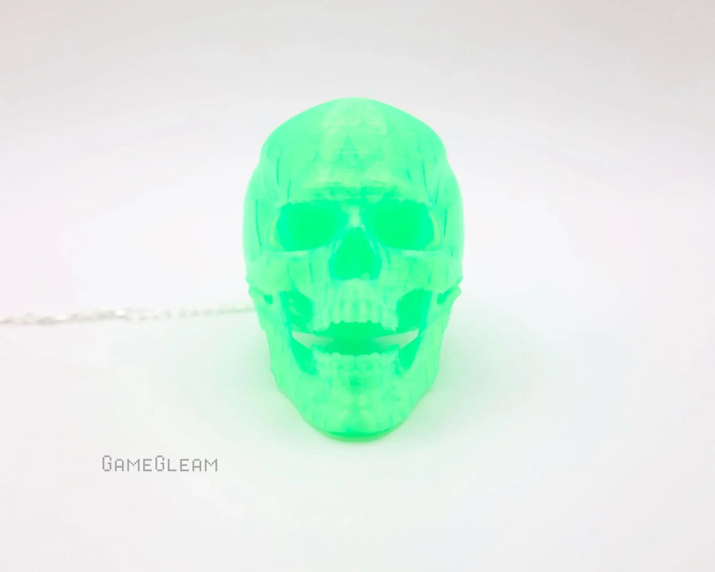Neon green translucent skull-shaped car charm on a white background