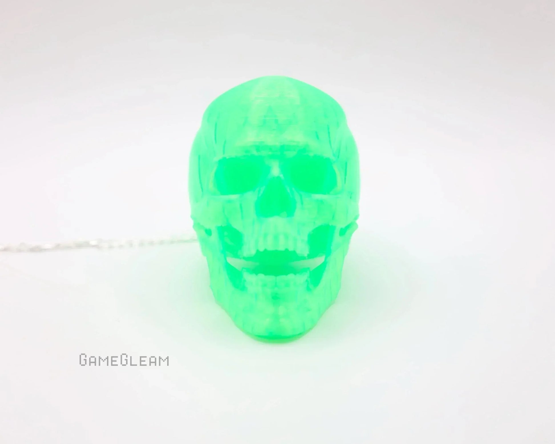 Neon green translucent skull-shaped car charm on a white background