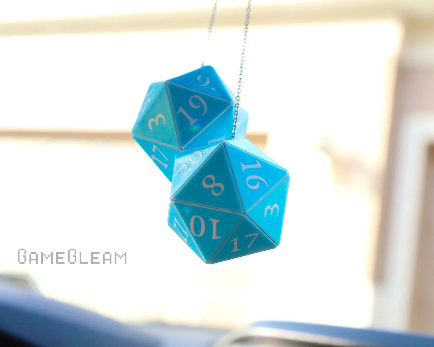 Blue twenty-sided dice hanging as a car charm with white numbering, sunlight background
