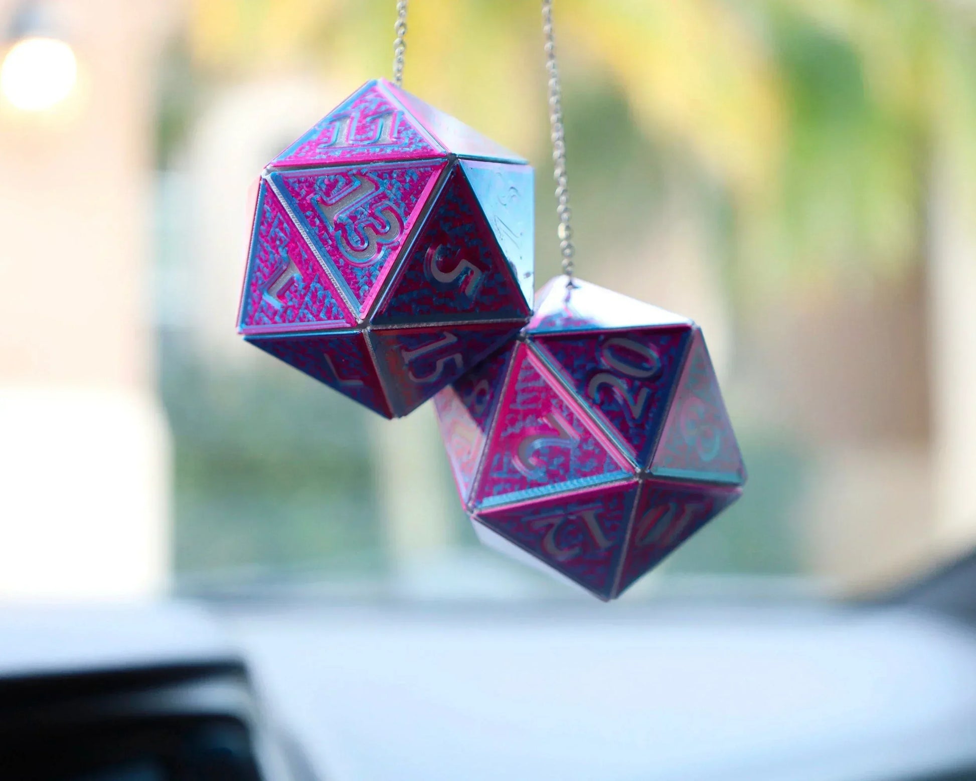 Holographic purple and blue twenty-sided dice car charm hanging from rearview mirror