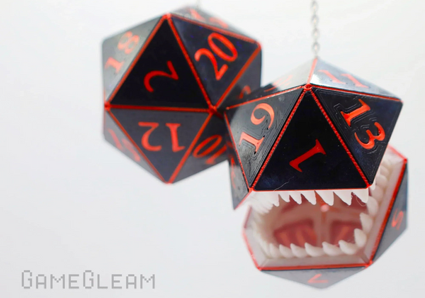 Two mimic D20 polyhedral car dice with red numbers on a white background, one open to reveal teeth.
