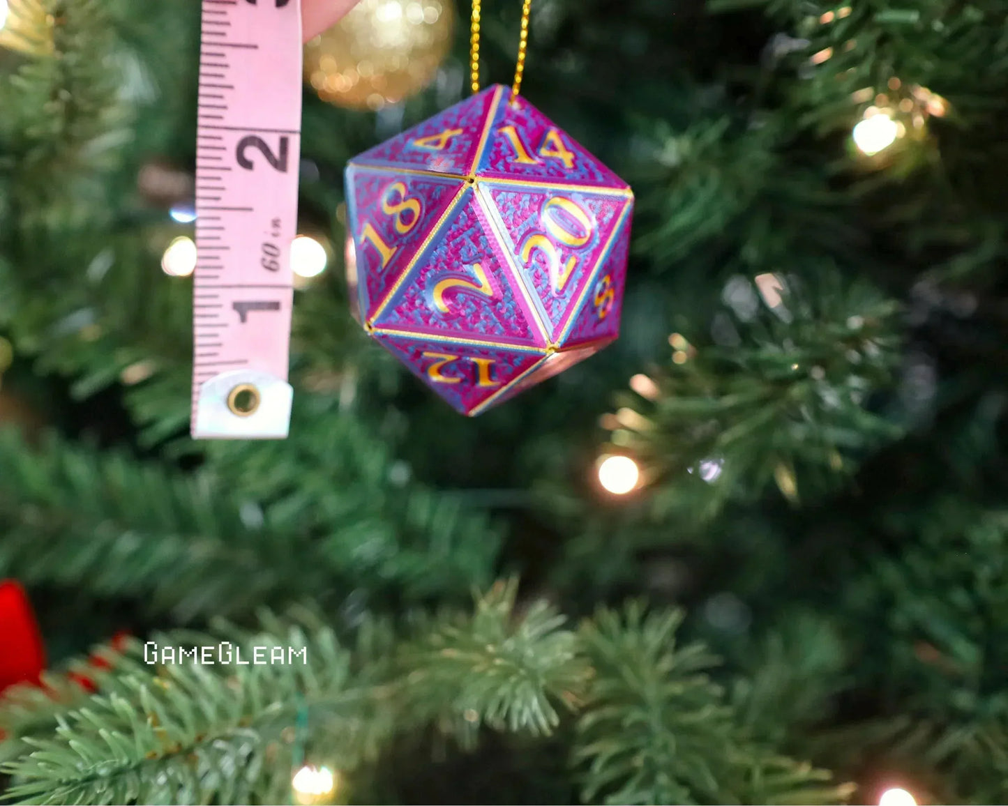 Colorful holographic 20-sided dice ornament hanging on Christmas tree by measuring tape