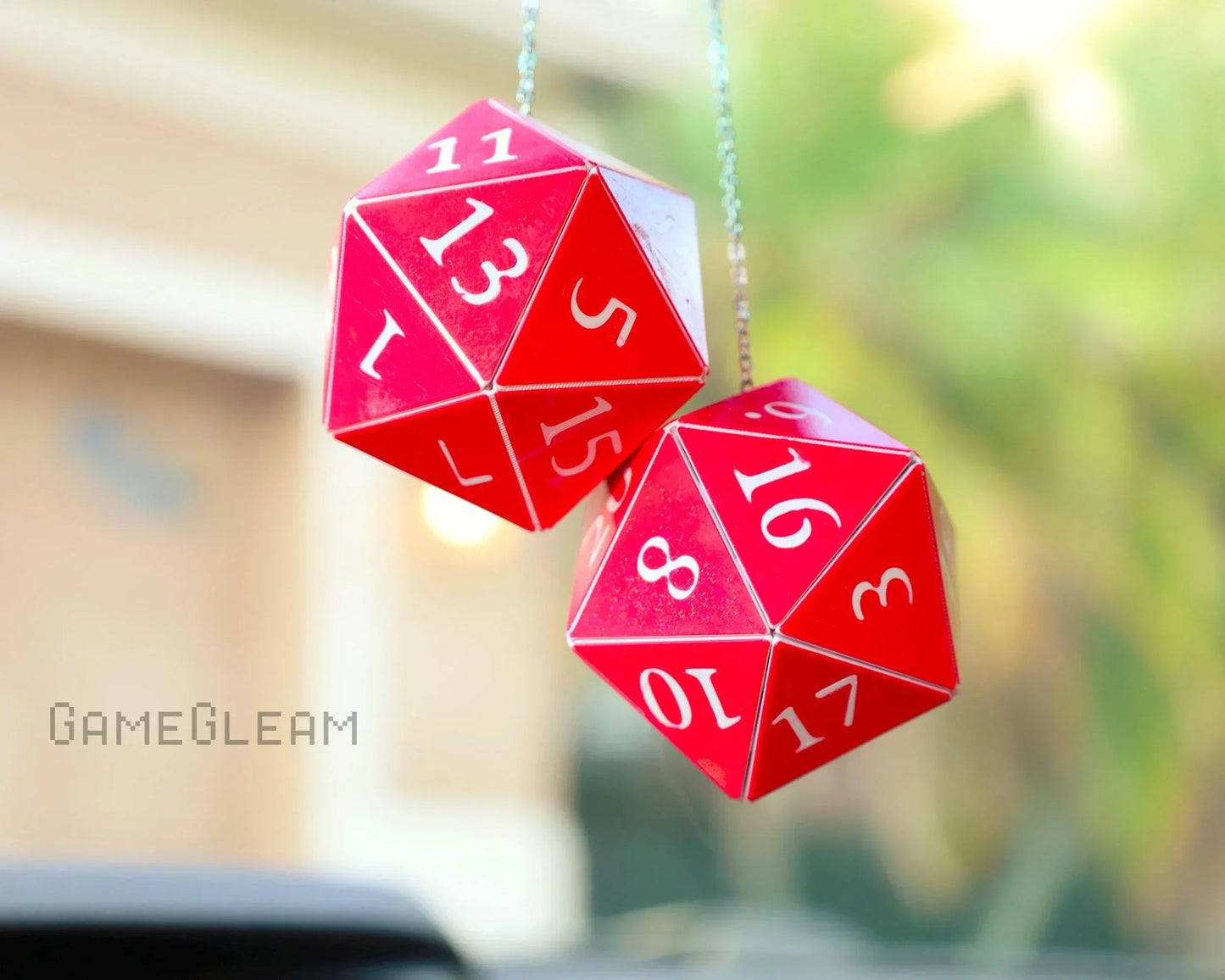 Red twenty-sided dice car mirror charm with white numbers, hanging indoors