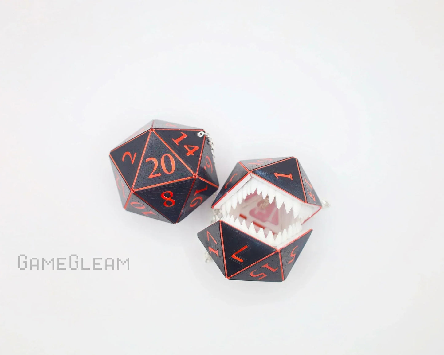 Handmade black and red D20 dice charms, one with monster teeth and open mouth, on white background