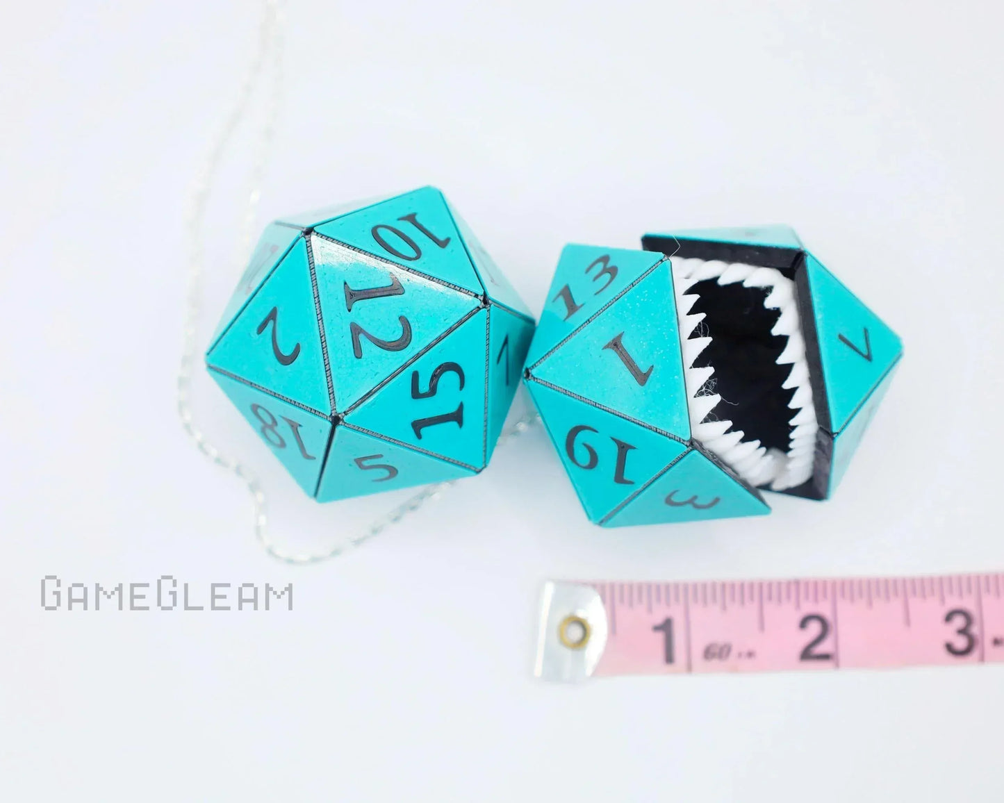 Aqua blue twenty-sided dice charm with monster teeth, chain, and measuring tape