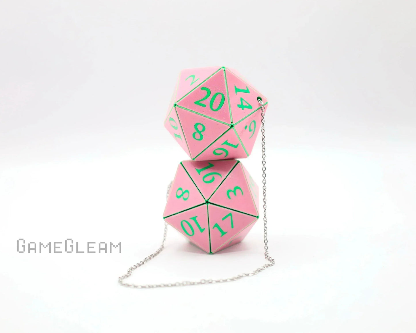 Pink twenty-sided dice car charm with green numbers and silver chain on white background.