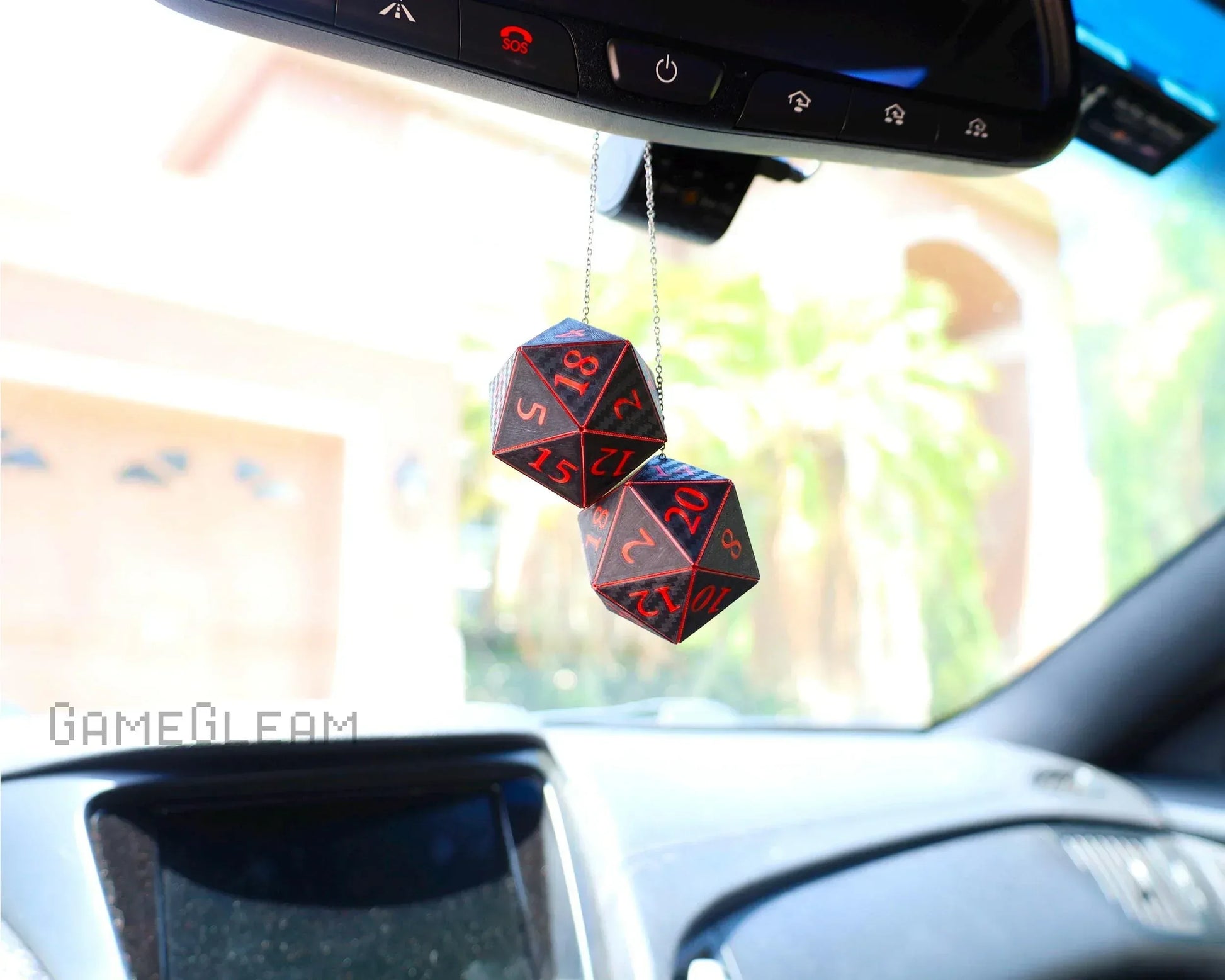 Pair of handmade black and red 20-sided dice hanging from a car rearview mirror