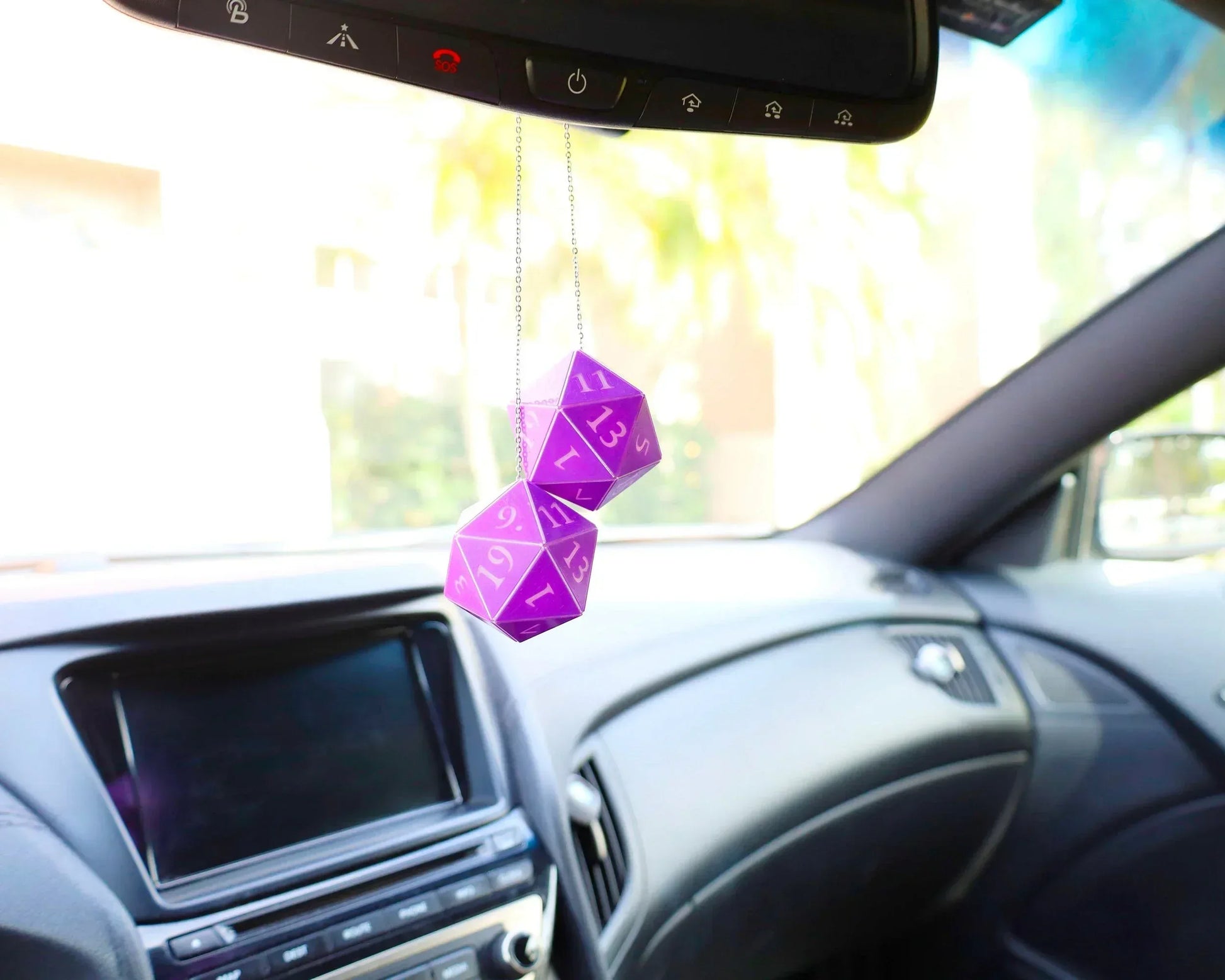 Purple twenty-sided dice car mirror charm for tabletop RPG fans, hanging in a modern car interior